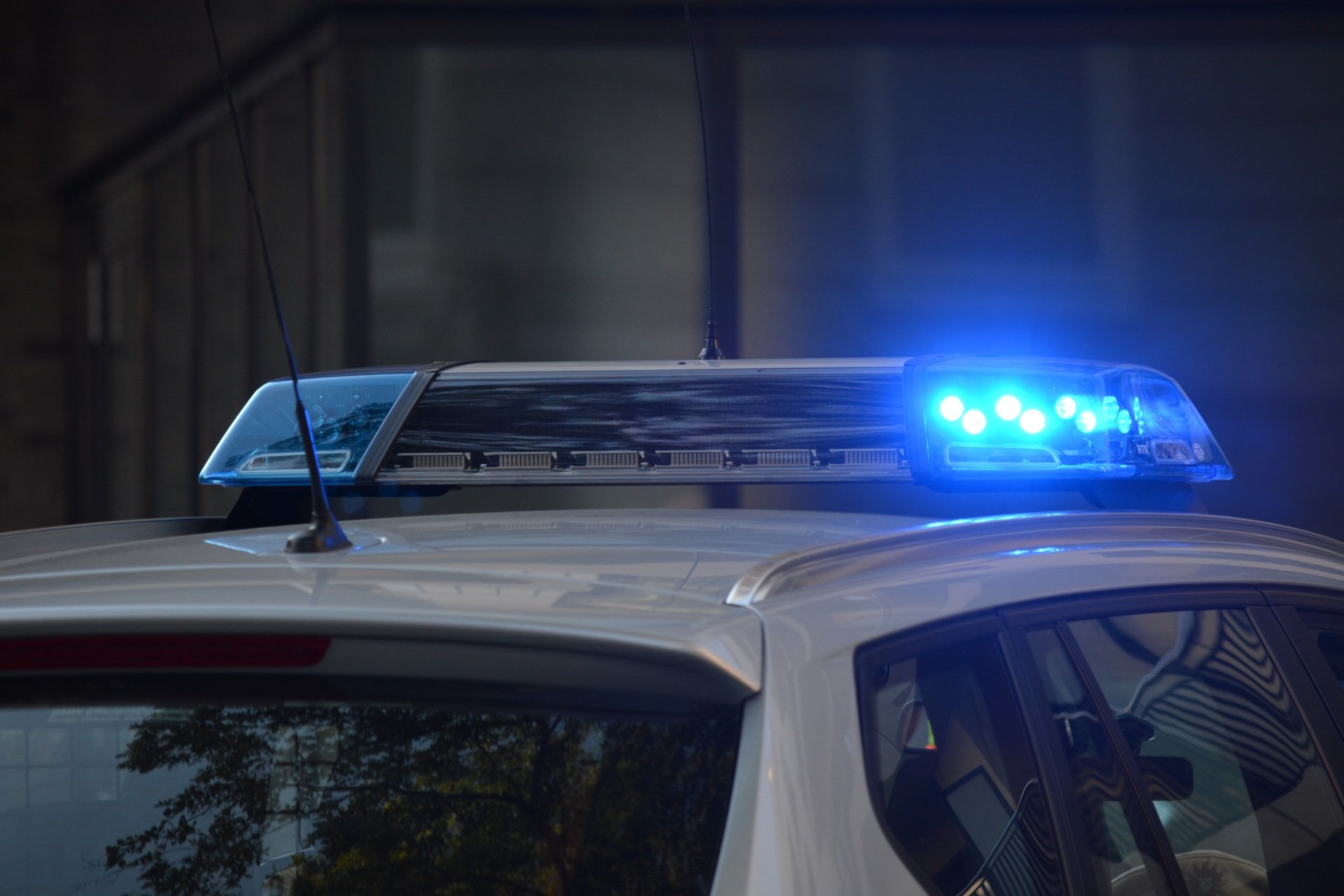 A police officer is riding a motorcycle down the street.