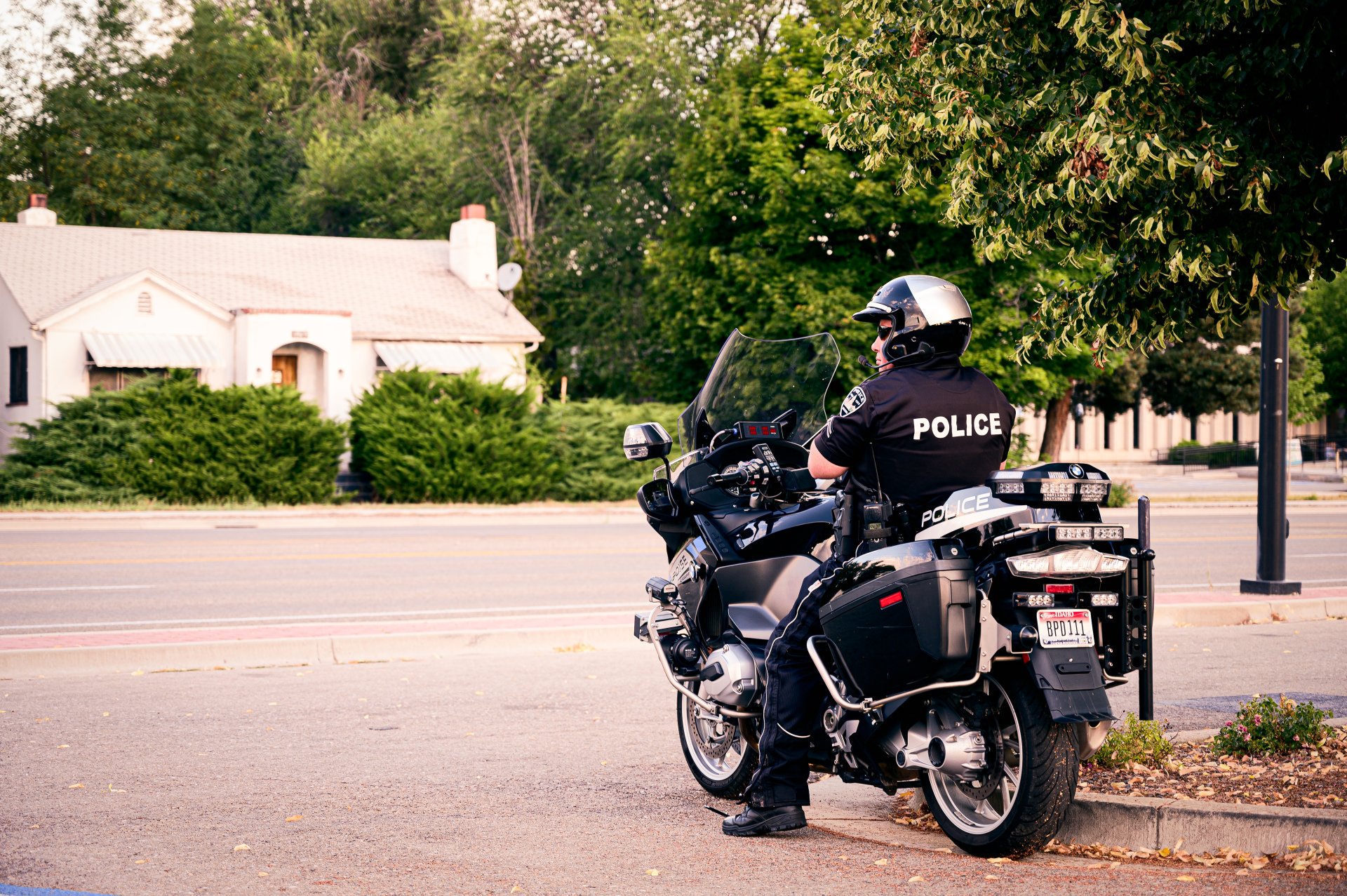 A police officer is riding a motorcycle down the street.