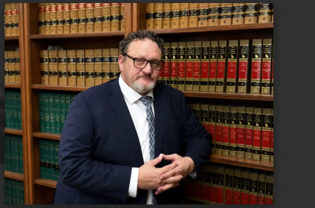 Attorney Frank Carter standing in the firm's law library