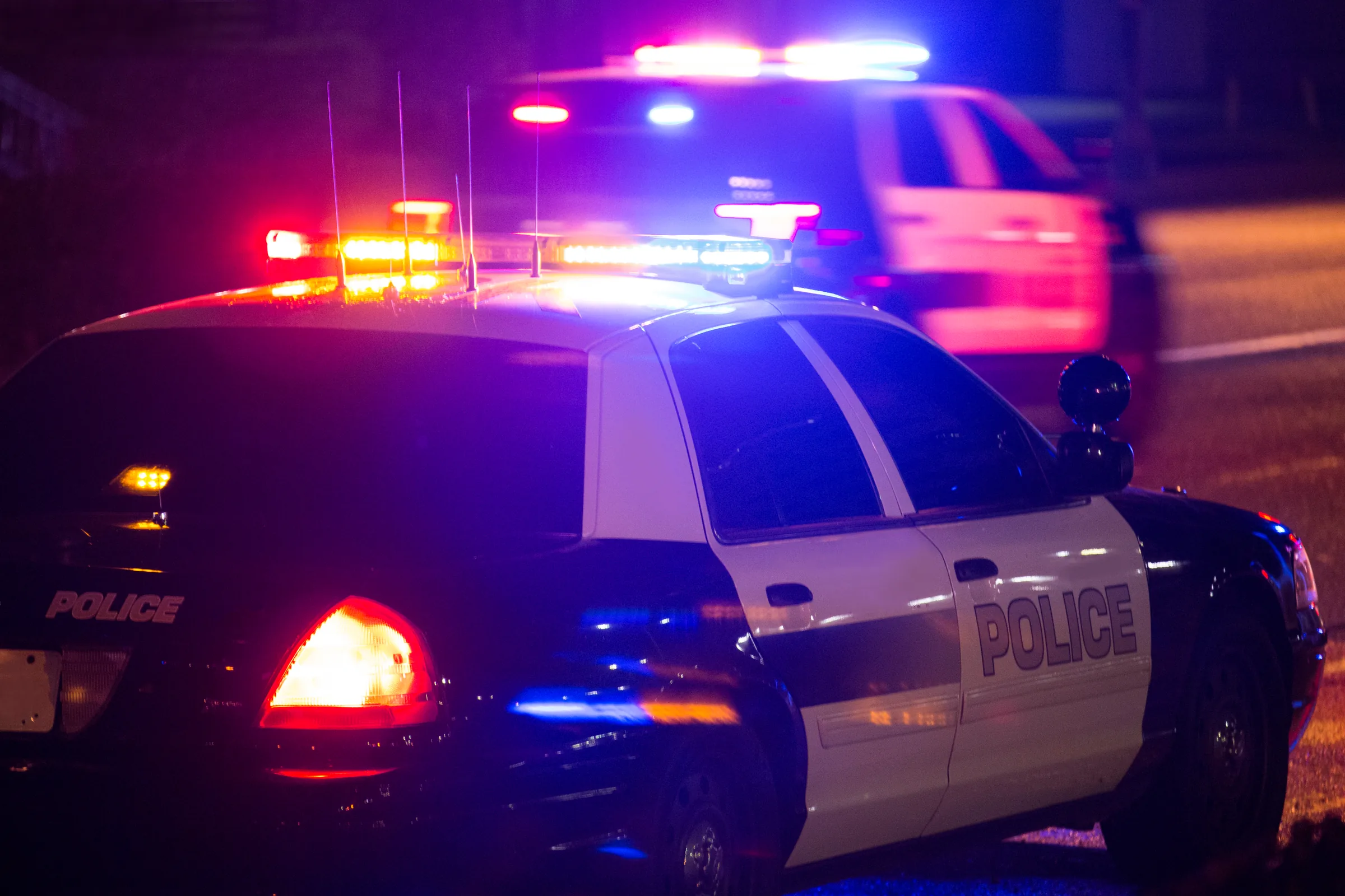 Police cruiser with flashing lights on a dark street