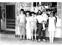 The bakery crew lined up outside the shop under the Open sign