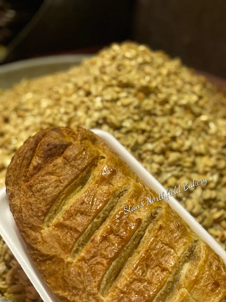 A braided nut roll beside a tray of chopped nuts