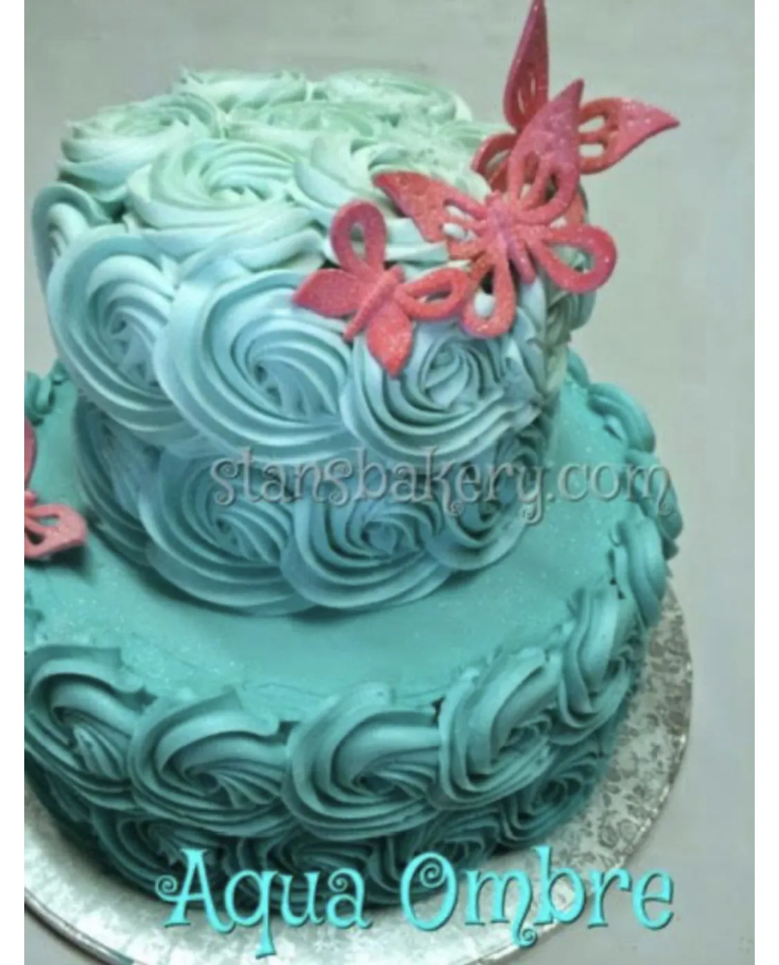 An aqua ombre rosette cake with a sugar butterfly