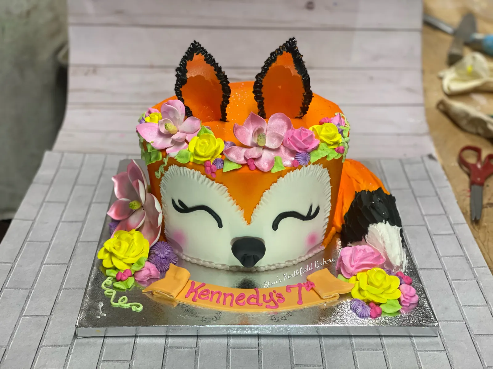 A fox face cake with a crown of flowers
