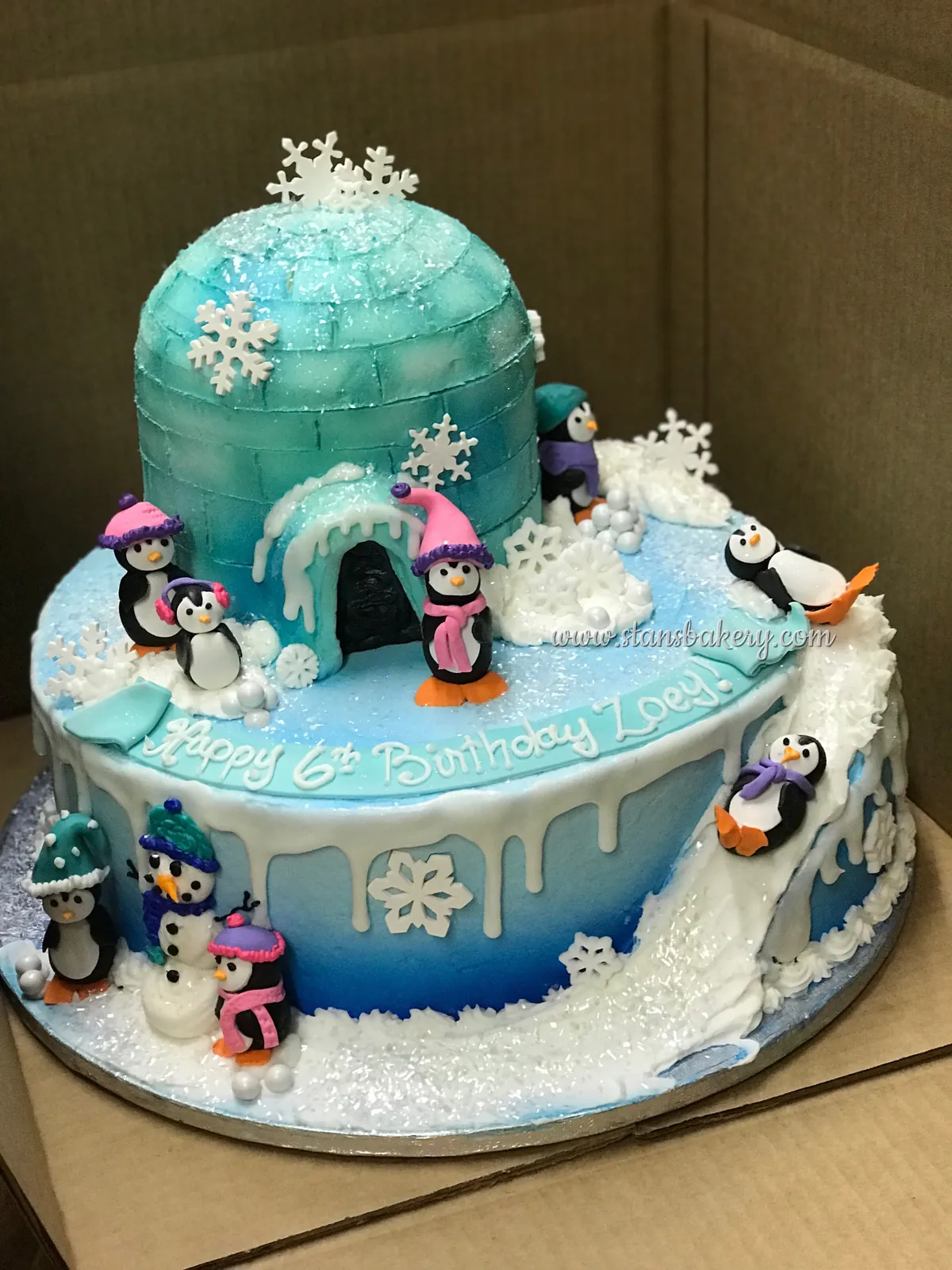 A winter cake with an igloo and penguins