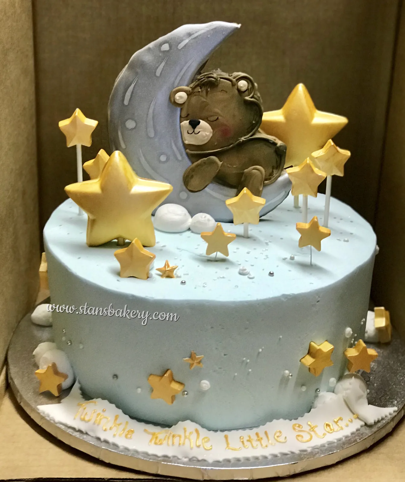A baby cake with a teddy bear on a moon and gold stars