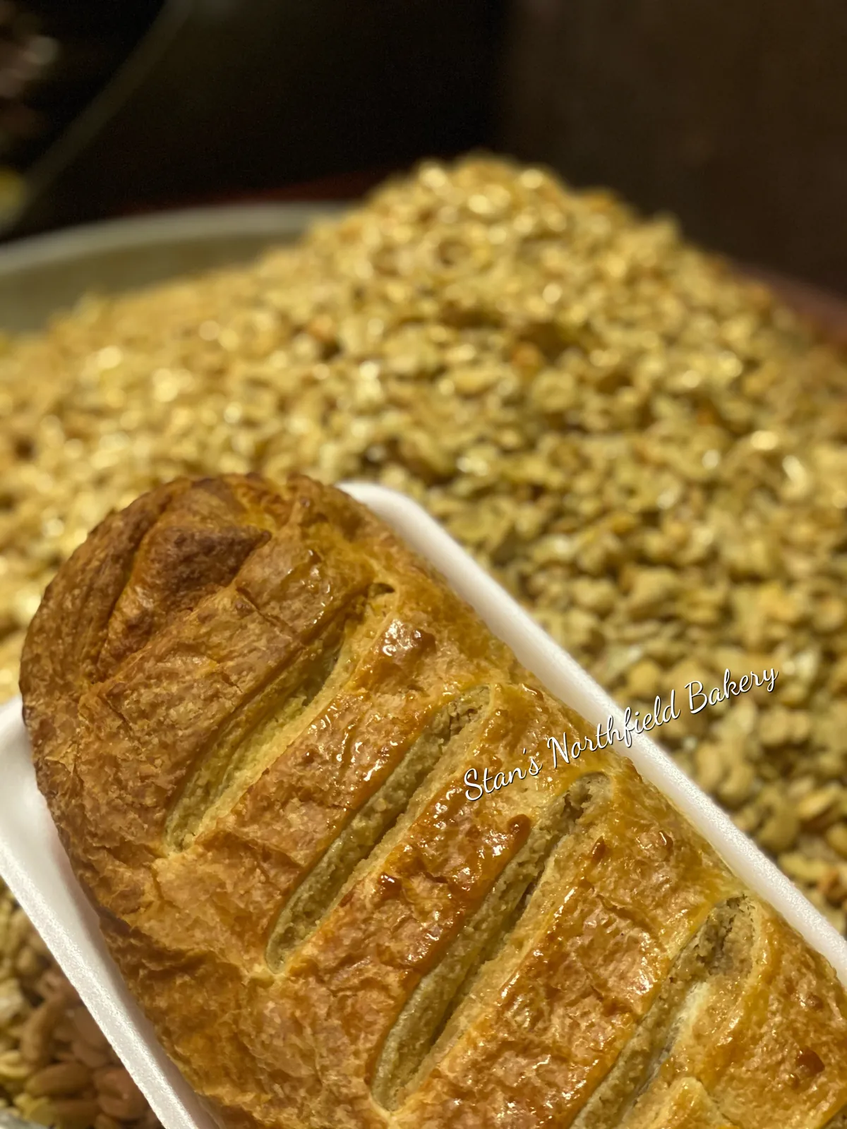 A braided nut roll beside a tray of chopped nuts