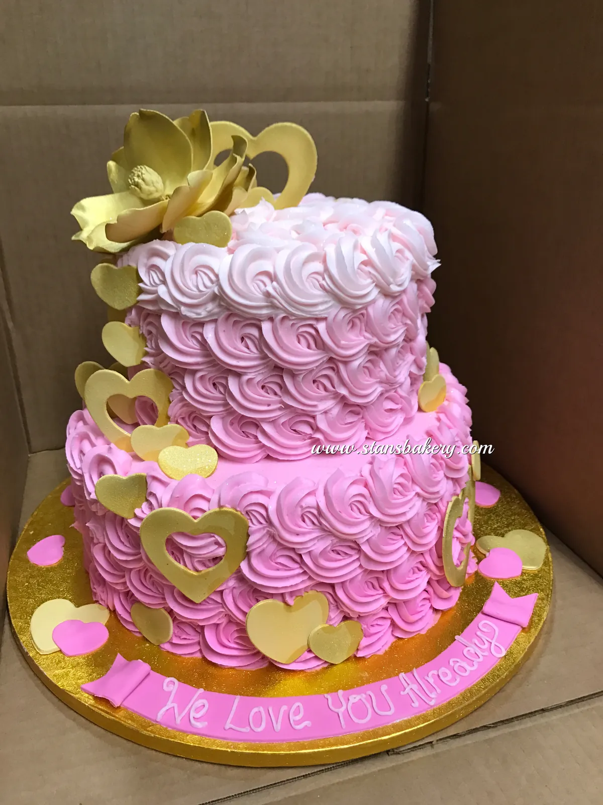 A pink rosette cake with gold accents