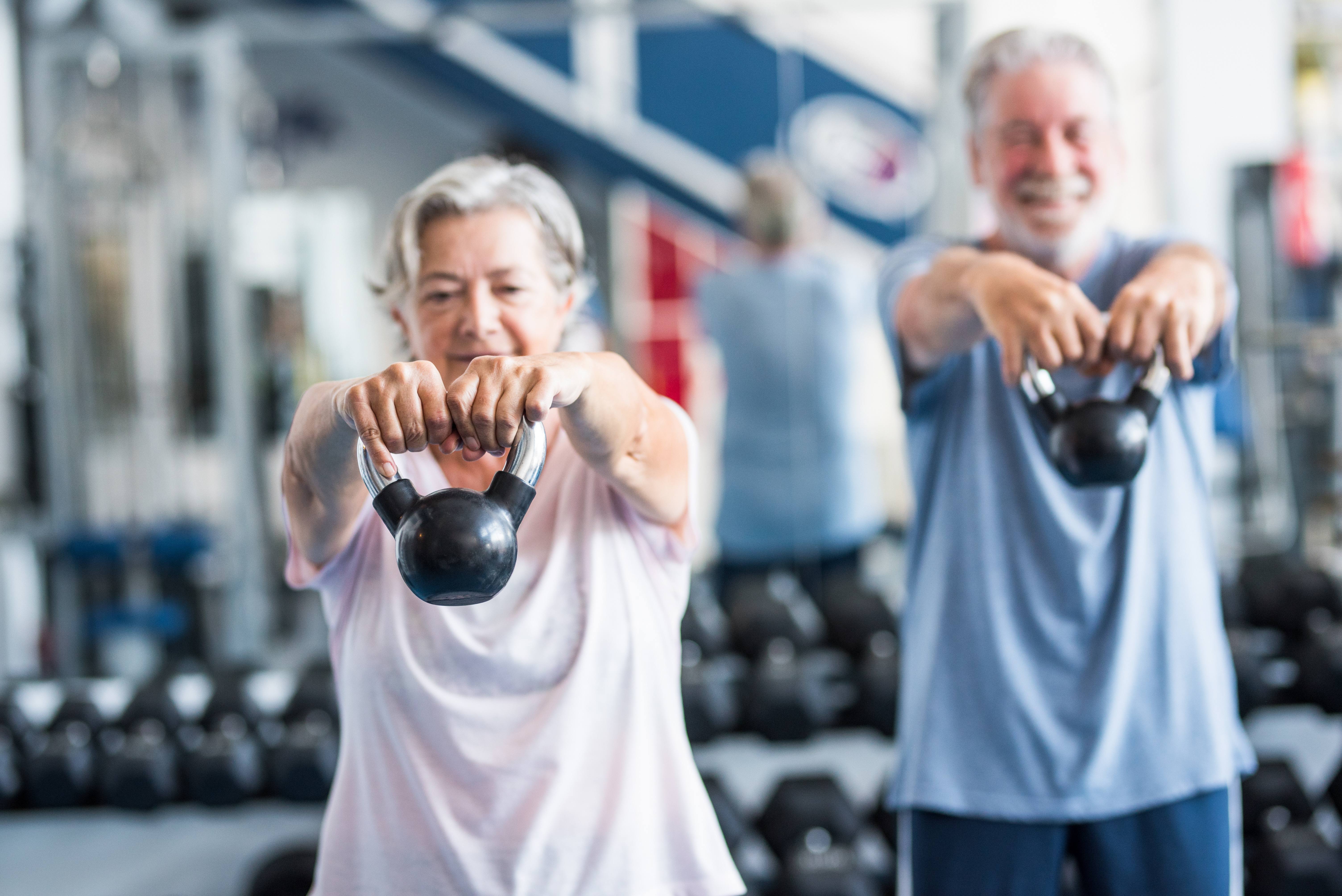 Two people lifting kettlebells stock image