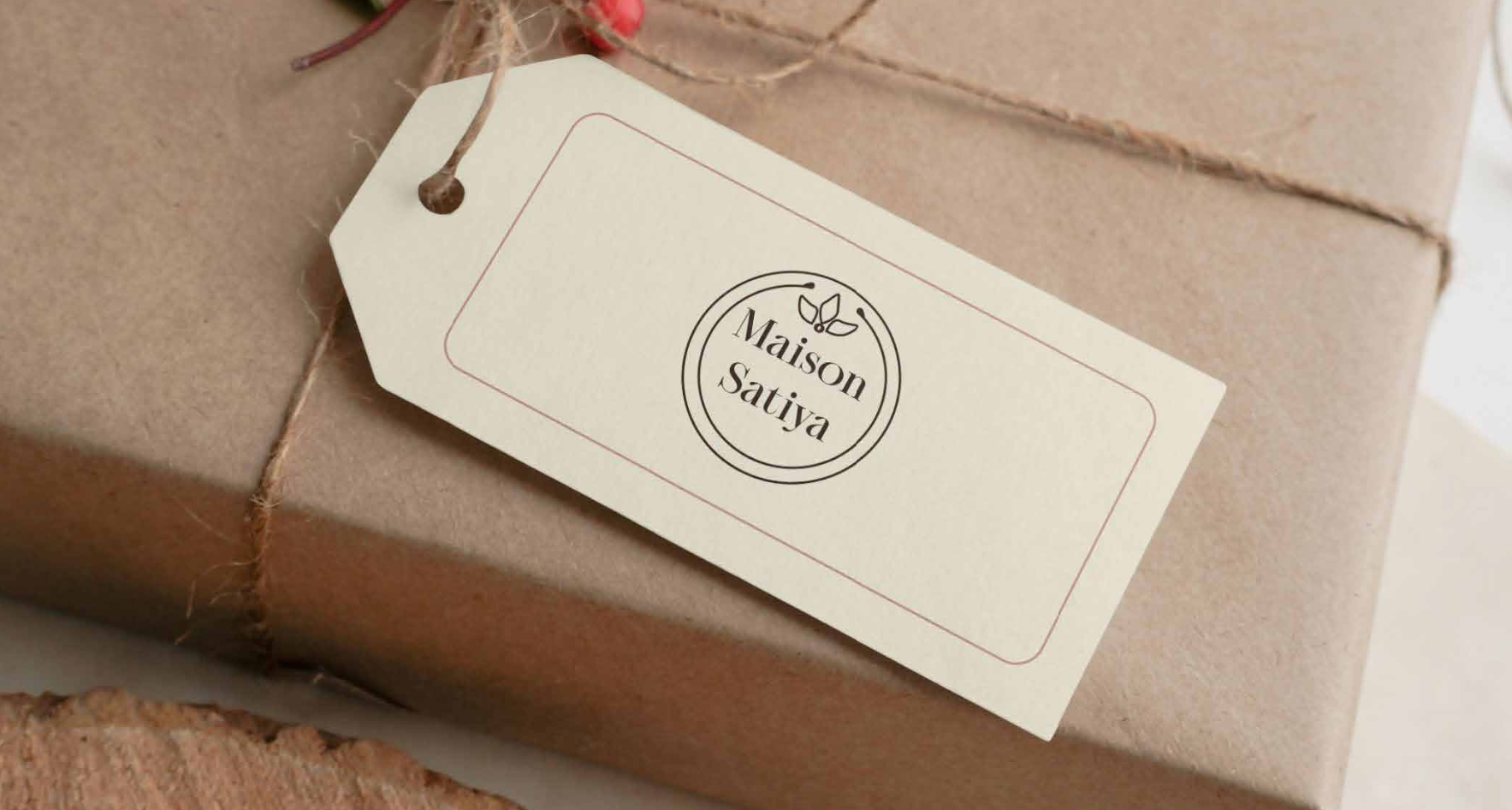 Brown gift box wrapped with twine and a white tag attached, featuring the text 'Maison Satiya' inside a circular logo with a small leaf design above.