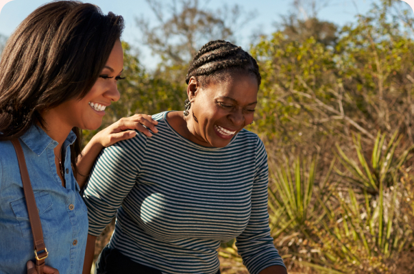 Two neighbors laughing together outdoors in their residential community