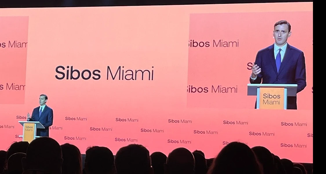 Speaker at the podium on the main stage at Sibos 2026 in Miami