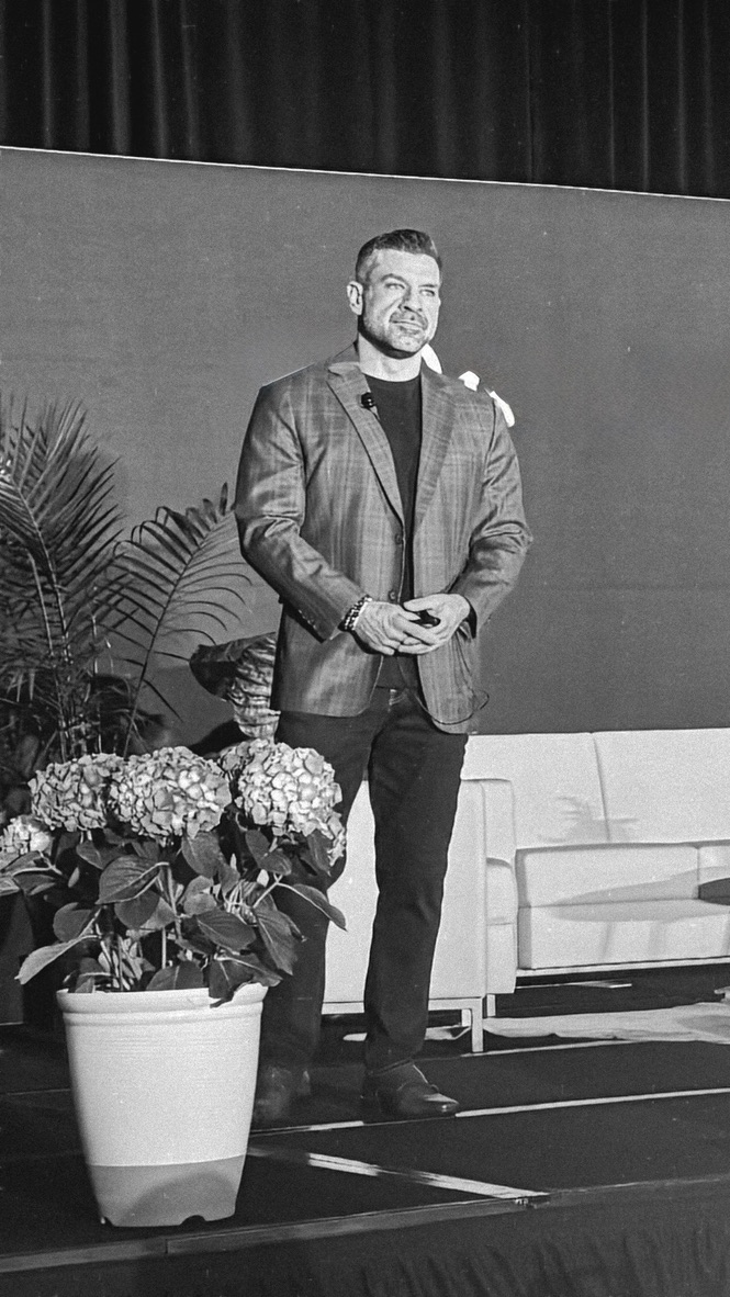 Mark Neuterman speaking on stage during a coaching session