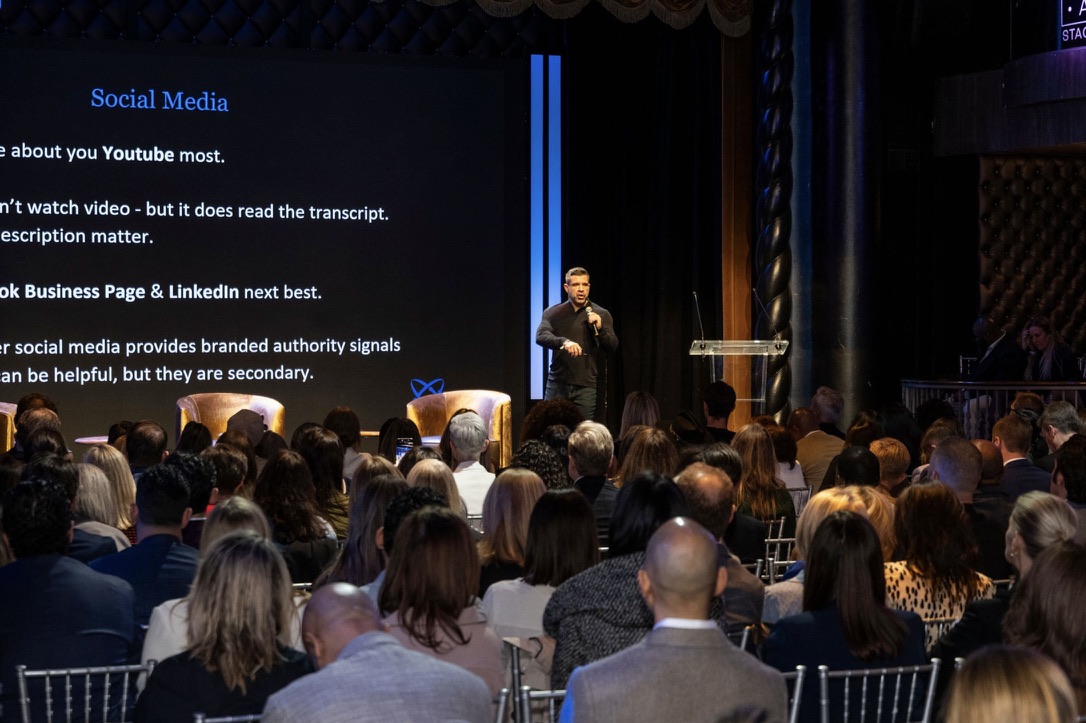 Mark Neuterman speaking to a full theater audience