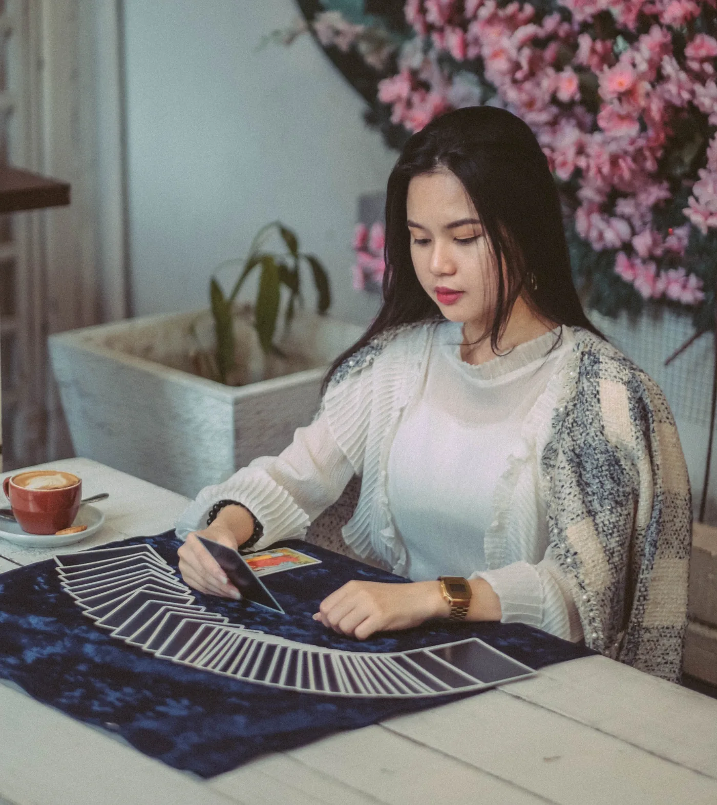 Domaiss Lew 在牌桌前展开塔罗牌