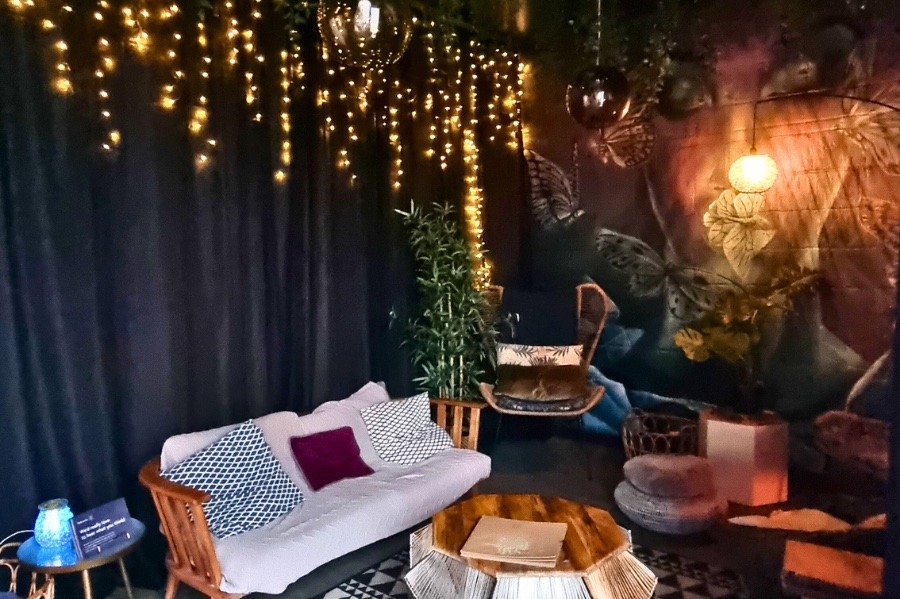Relaxation room at Floatworks Angel with a sofa, cushions, fairy lights and a butterfly mural