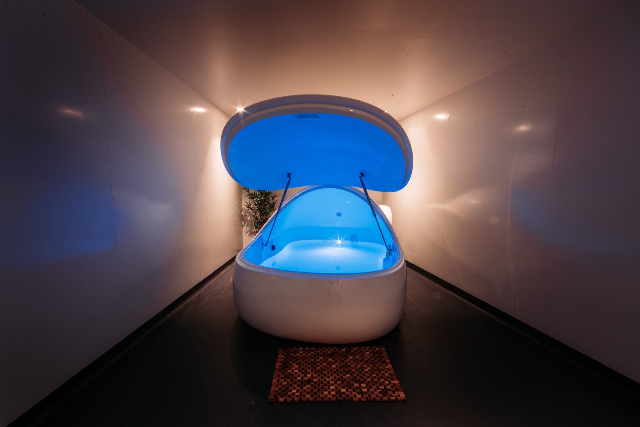 A float pod glowing blue in a private room at Floatworks Angel