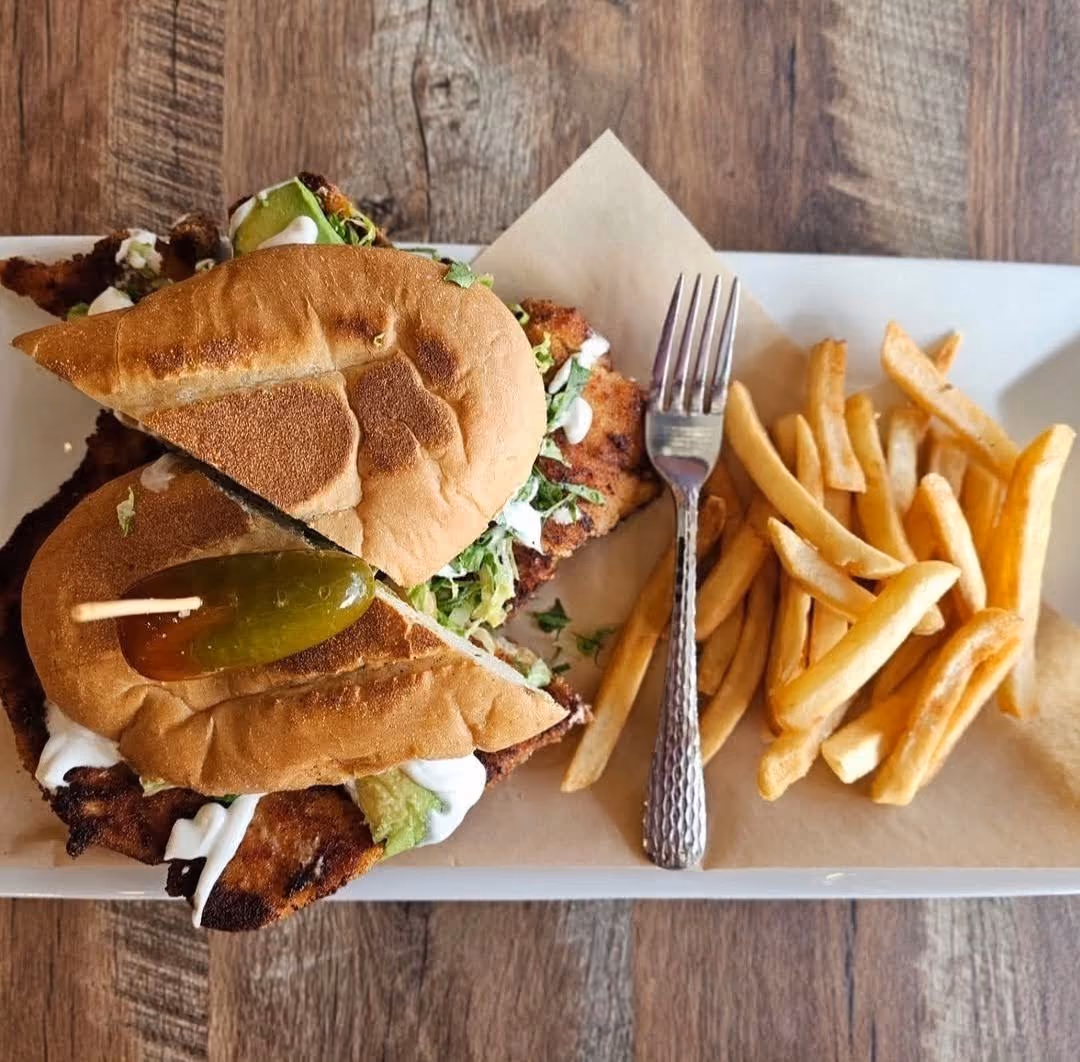 Torta sandwich cut in half next to a pile of french fries