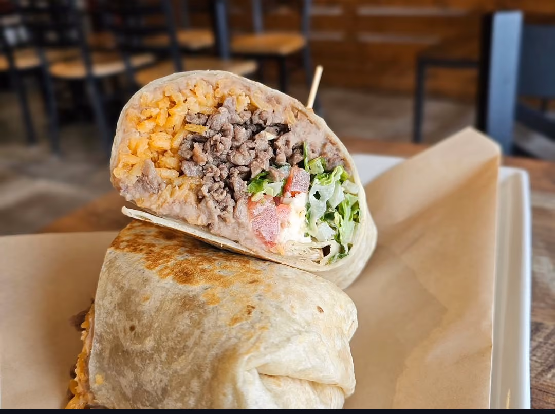 Burrito loaded with rice, beans, seasoned beef, and lettuce at Don Chuy's Taqueria