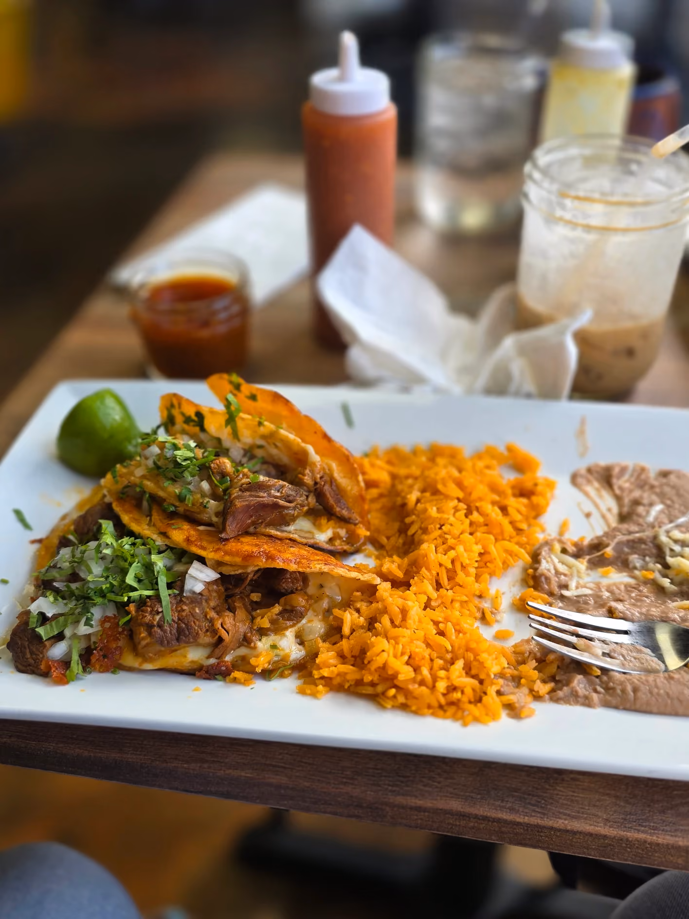 Crispy beef tacos dorados with Mexican rice, refried beans, and lime at Don Chuy's Taqueria