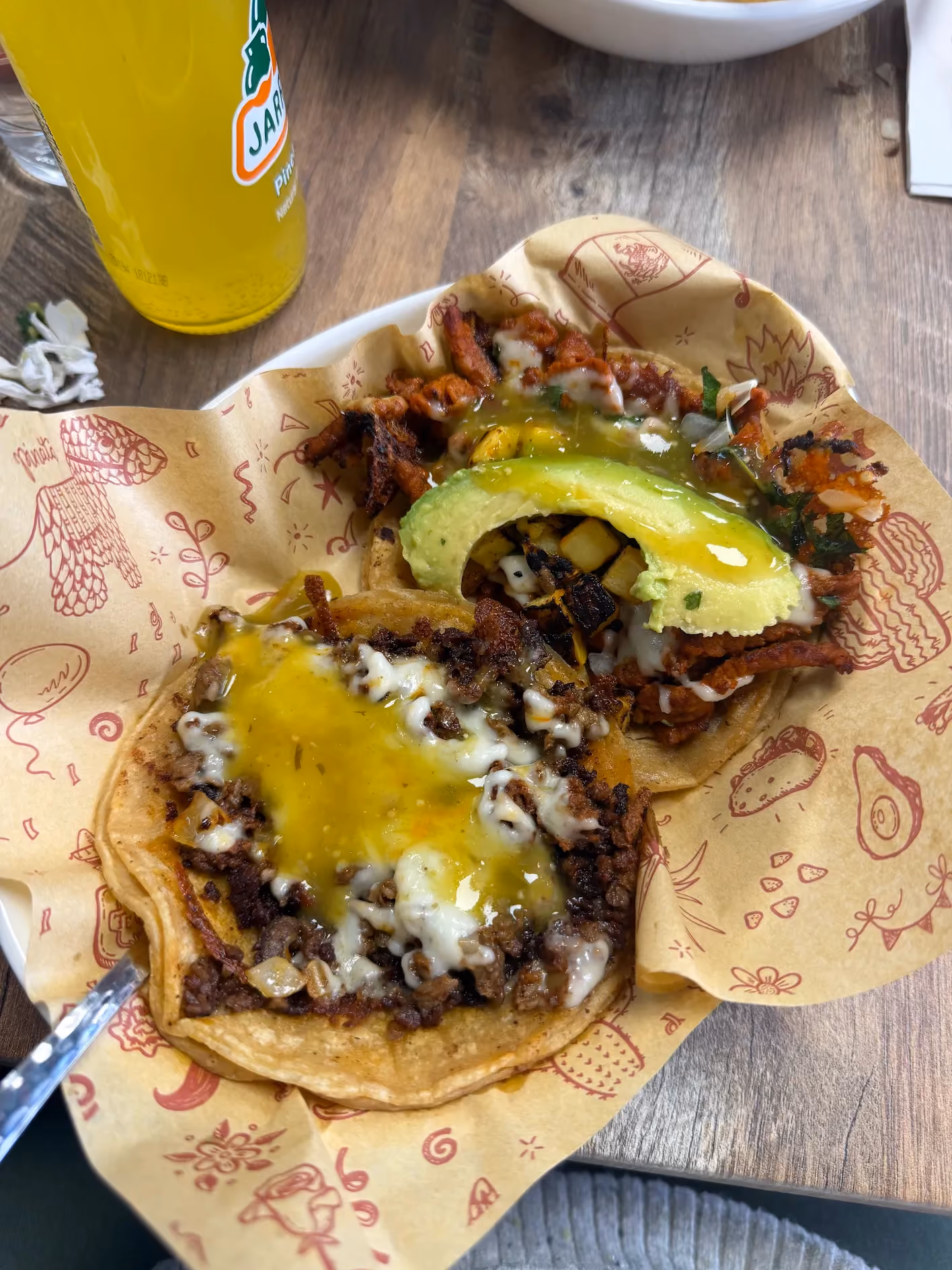 Two tacos with melted cheese, avocado, and salsa at Don Chuy's Taqueria
