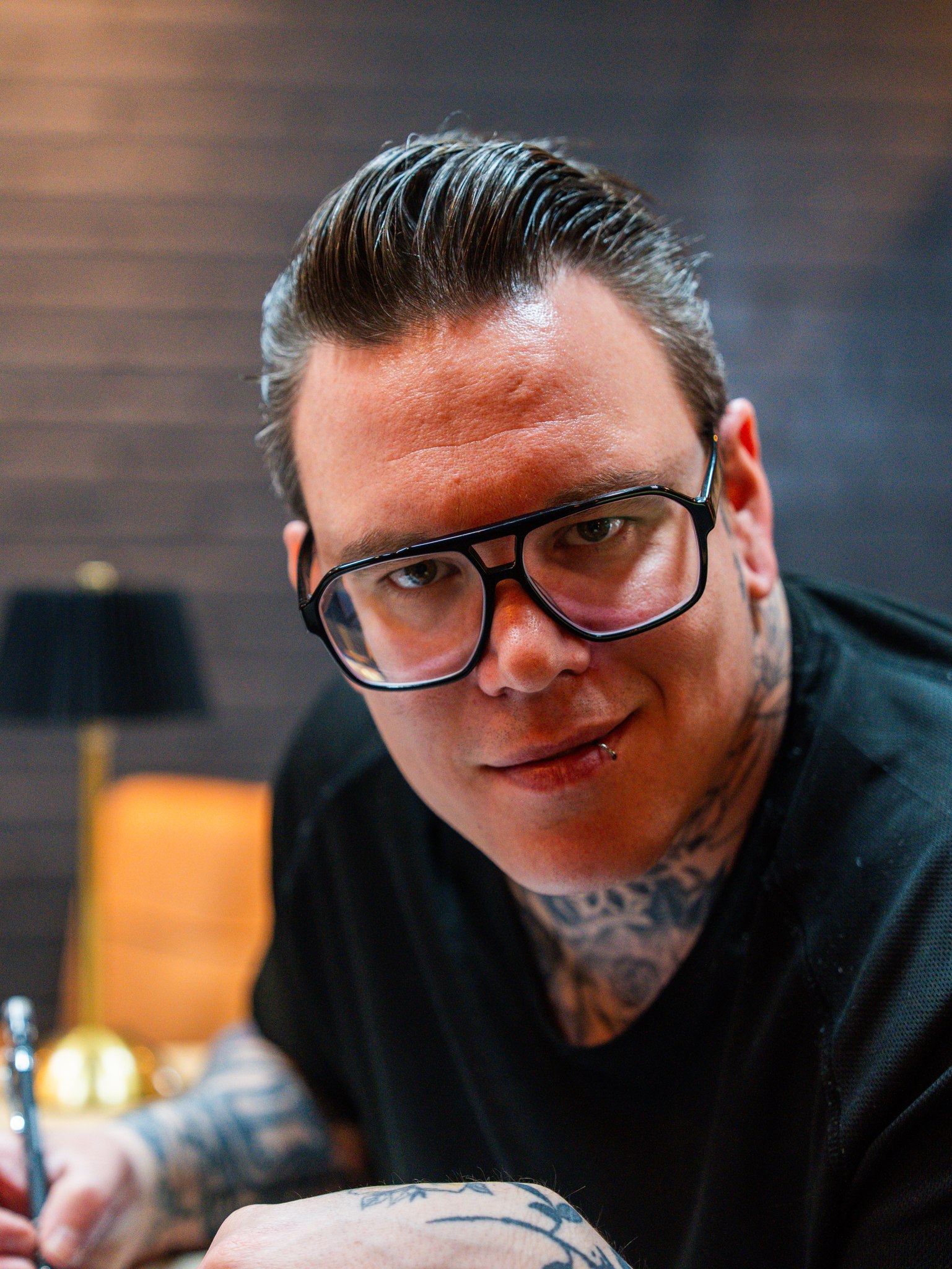 Tattooartiest van InkHeaven kijkt op tijdens het werk