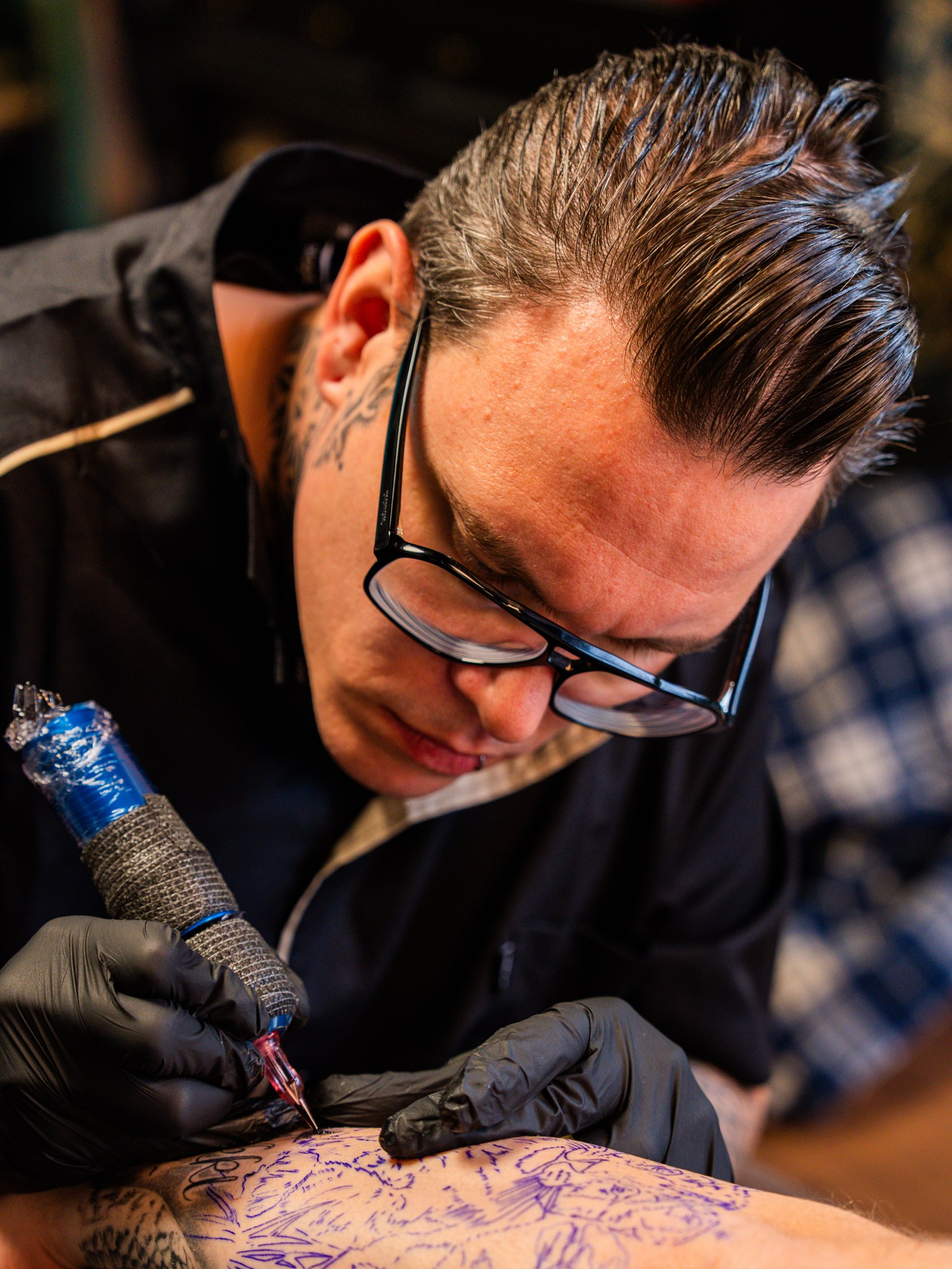 Tattooartiest van InkHeaven geconcentreerd tijdens het tatoeëren