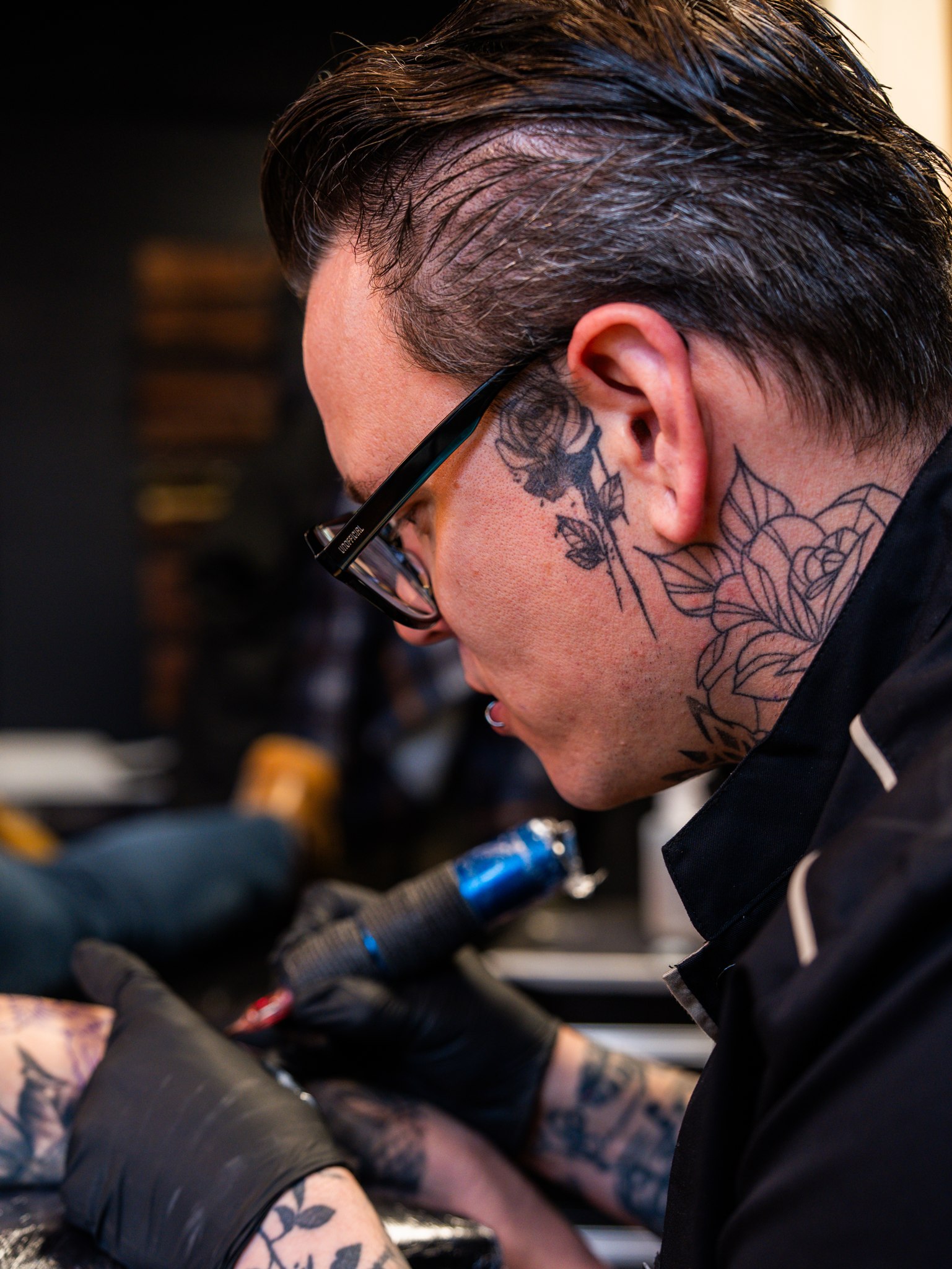 Tattooartiest van InkHeaven aan het werk, van opzij gefotografeerd