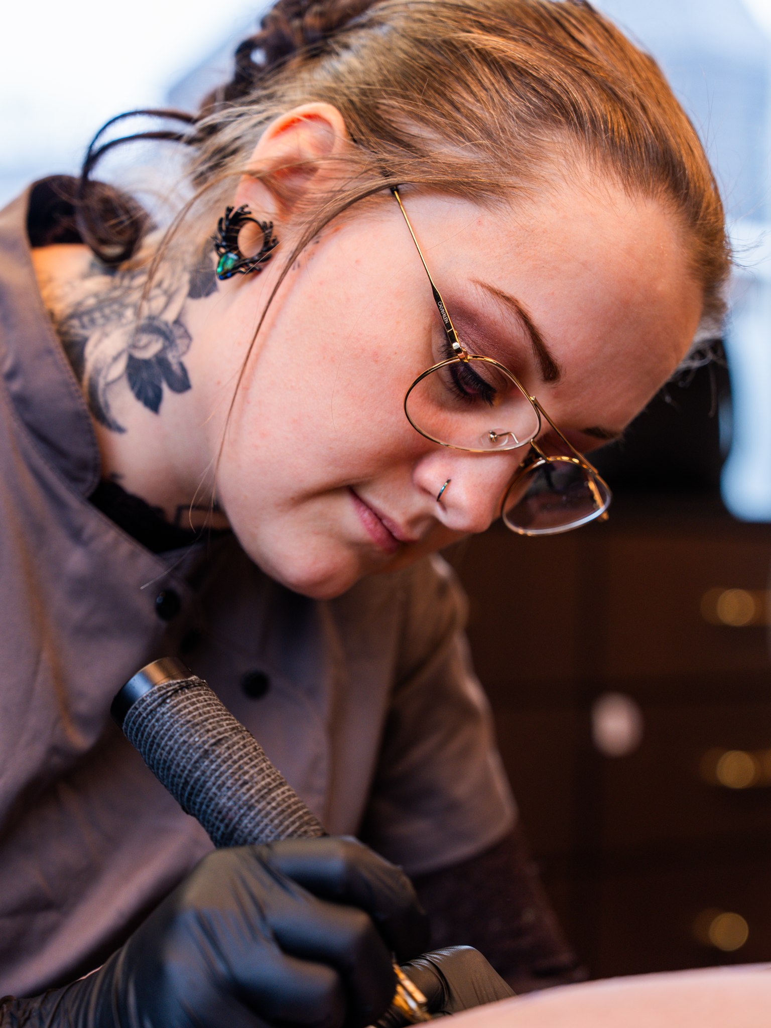Tattooartiest van InkHeaven werkt met aandacht aan een tatoeage