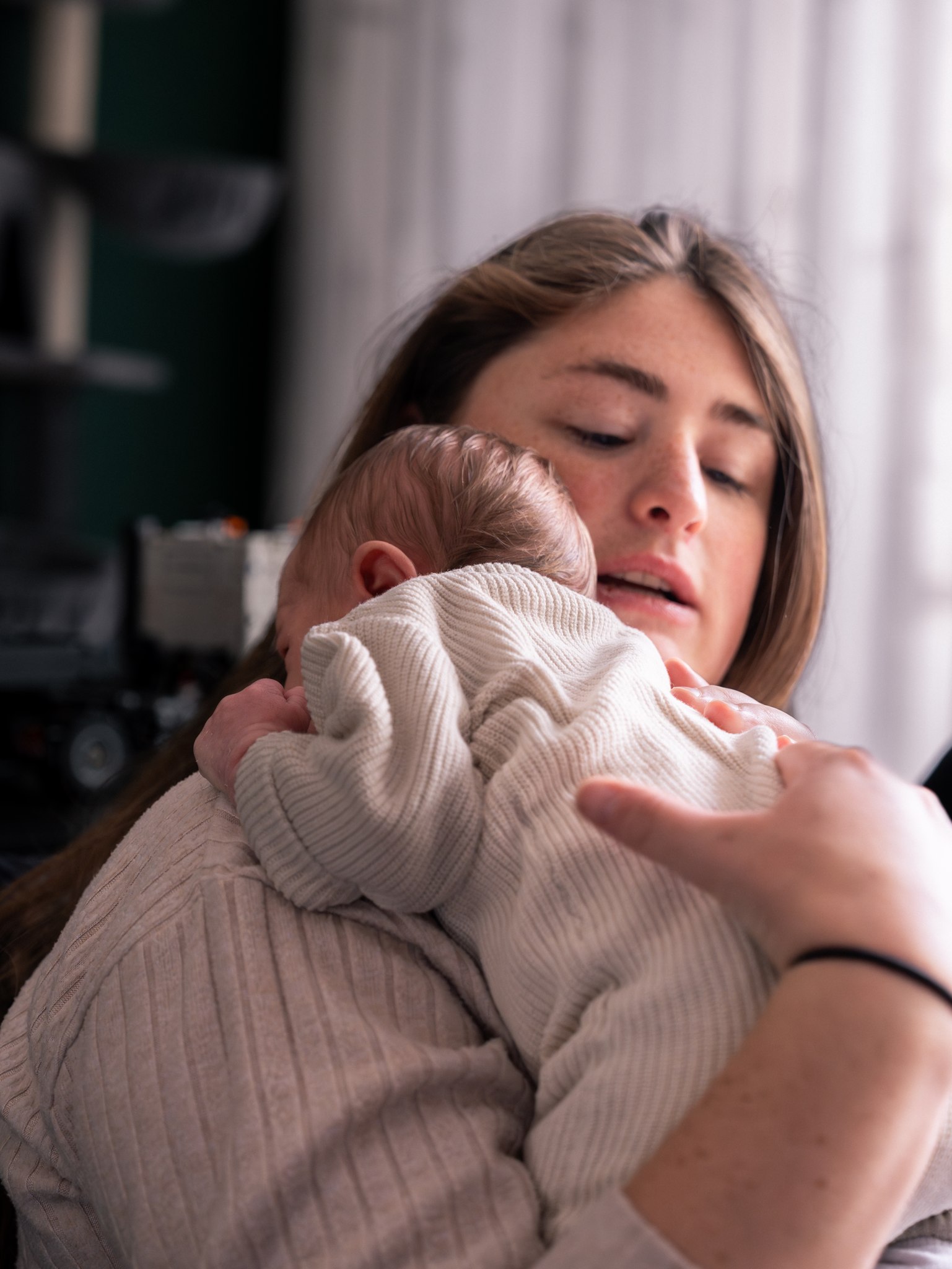 Moeder houdt haar pasgeboren baby dicht tegen zich aan
