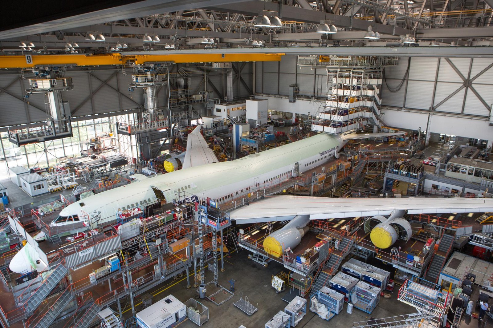 Boeing 747 während eines Kabinenumbaus bei Lufthansa Technik, umgeben von Arbeitsplattformen und Gerüsten im Hangar