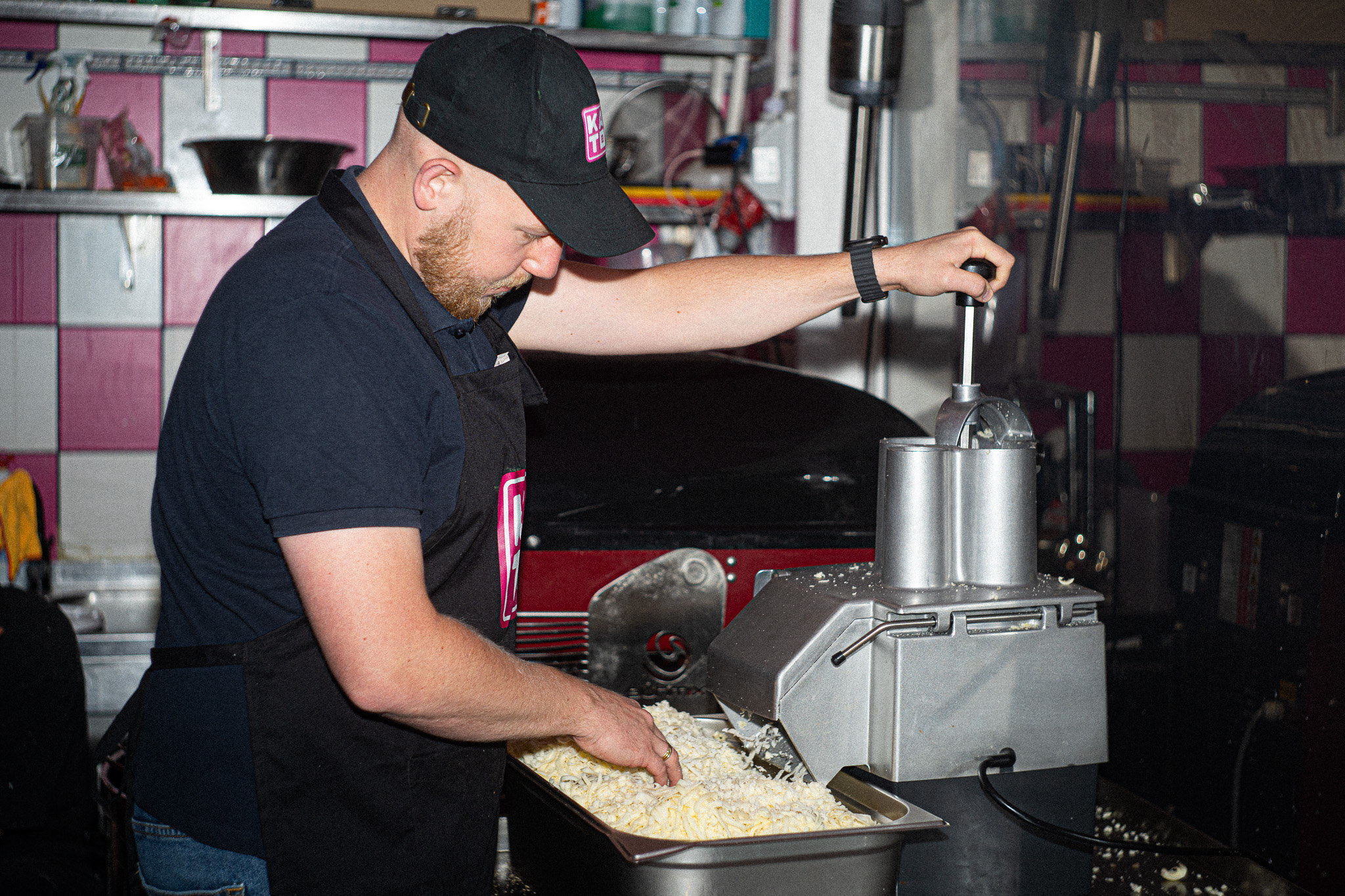 Pizzaiolo Kato Pizza przygotowuje ser w kuchni