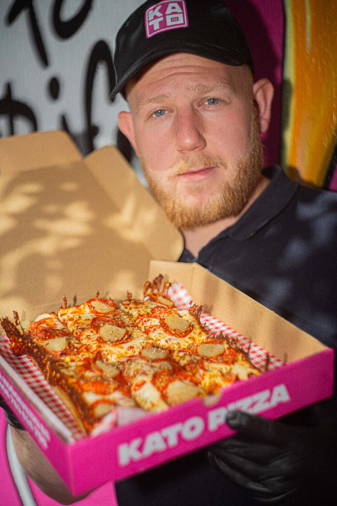 Pracownik Kato Pizza z pizzą w stylu Detroit w pudełku