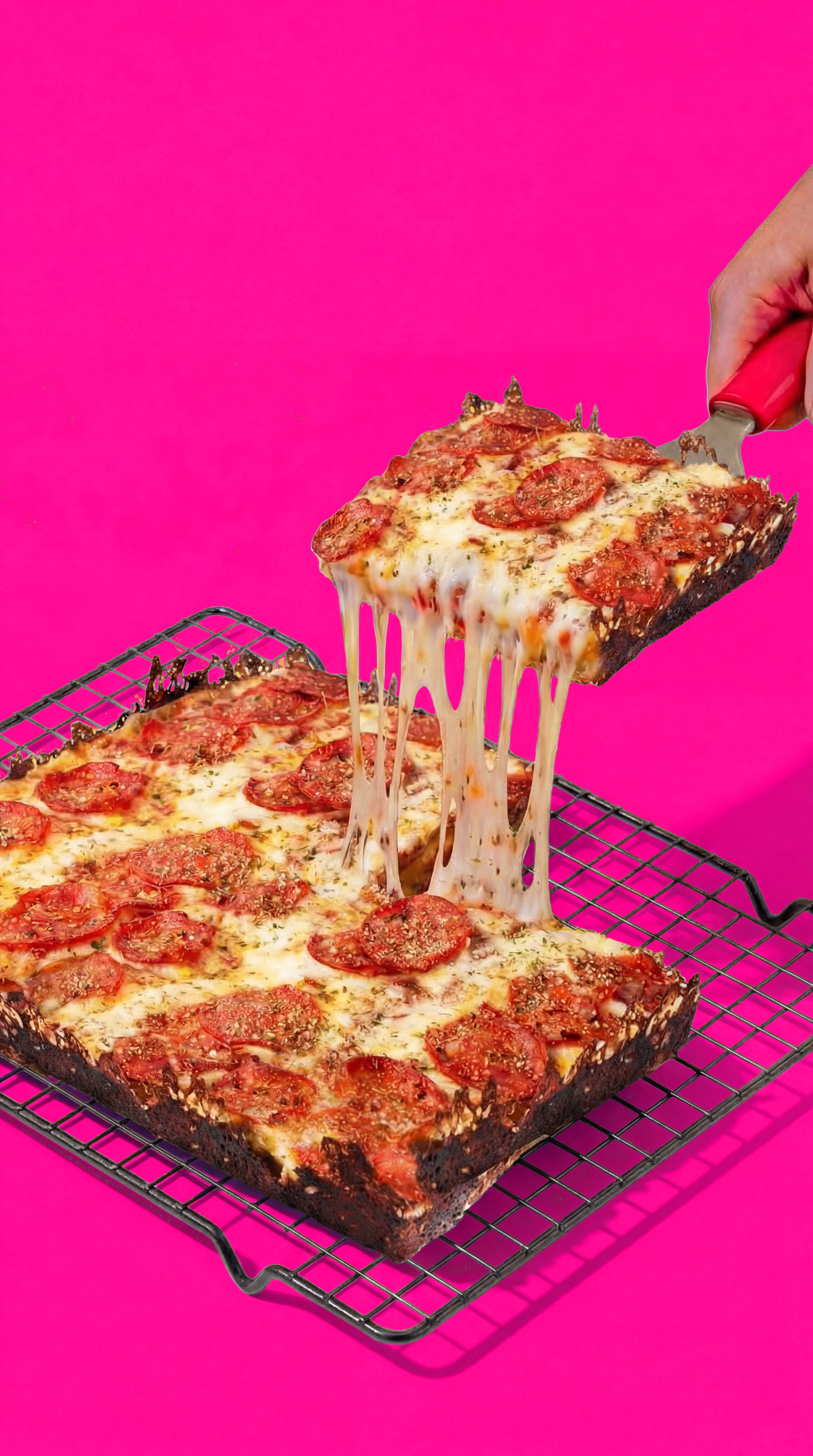 Kawałek pizzy Kato Pizza w stylu Detroit ciągnący się serem