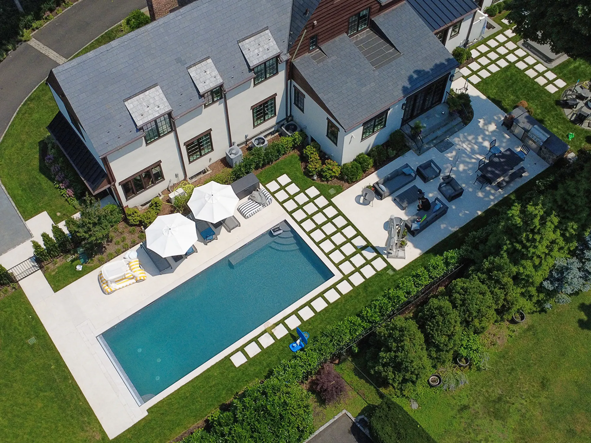 Aerial view of Tuscany Beige marble paving around a swimming pool and outdoor seating areas.