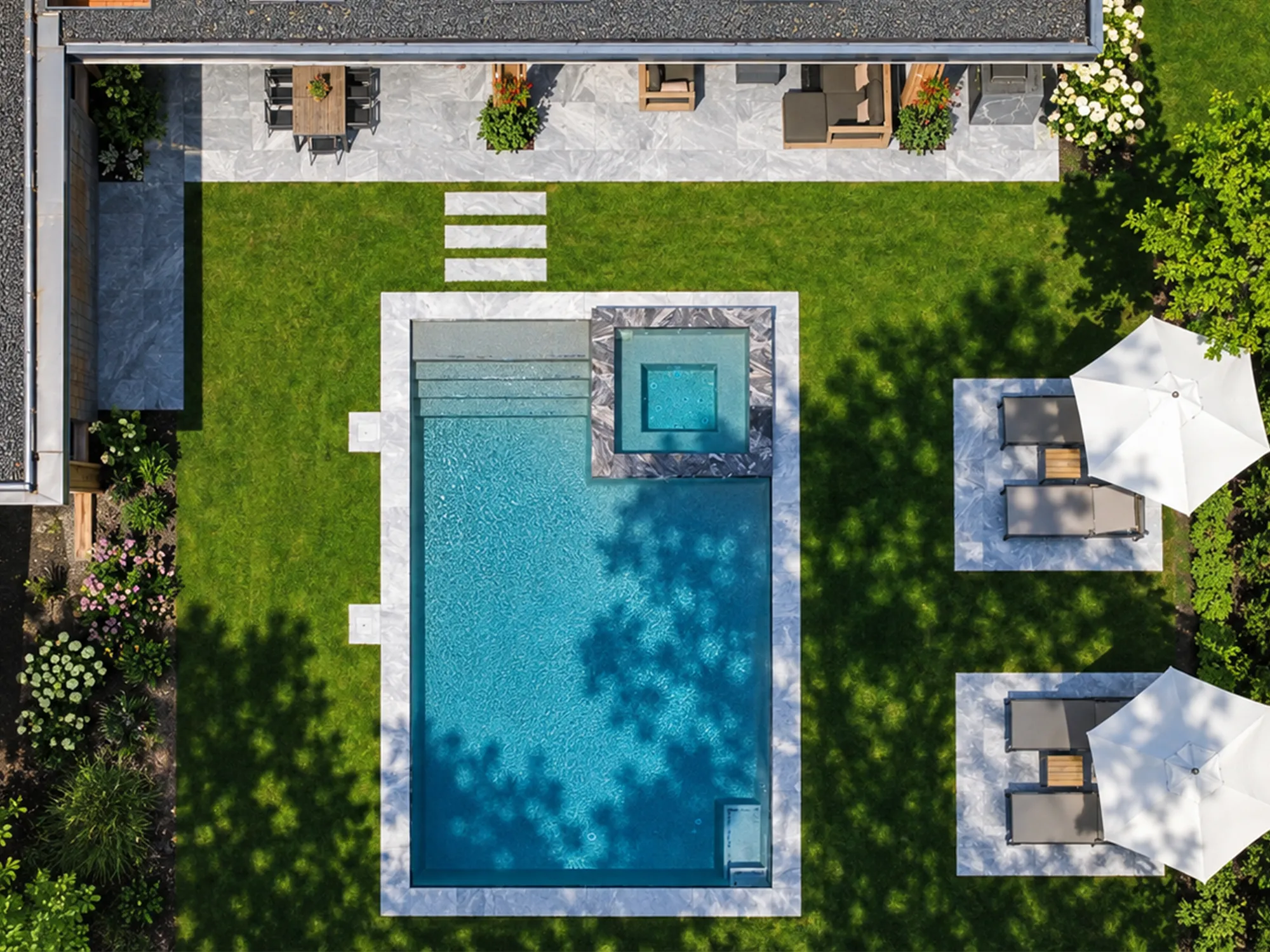 Aerial view of Ice Blue marble paving beside a swimming pool, with lawn stepping stones and shaded lounge areas.