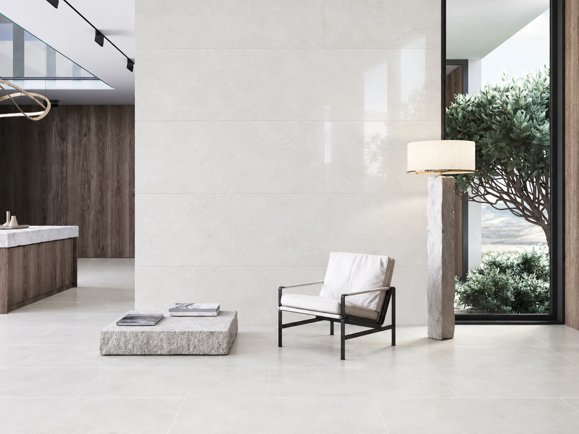 Large cream-colored stone tiles covering the wall and floor of a modern living space with a white armchair and wood accents.