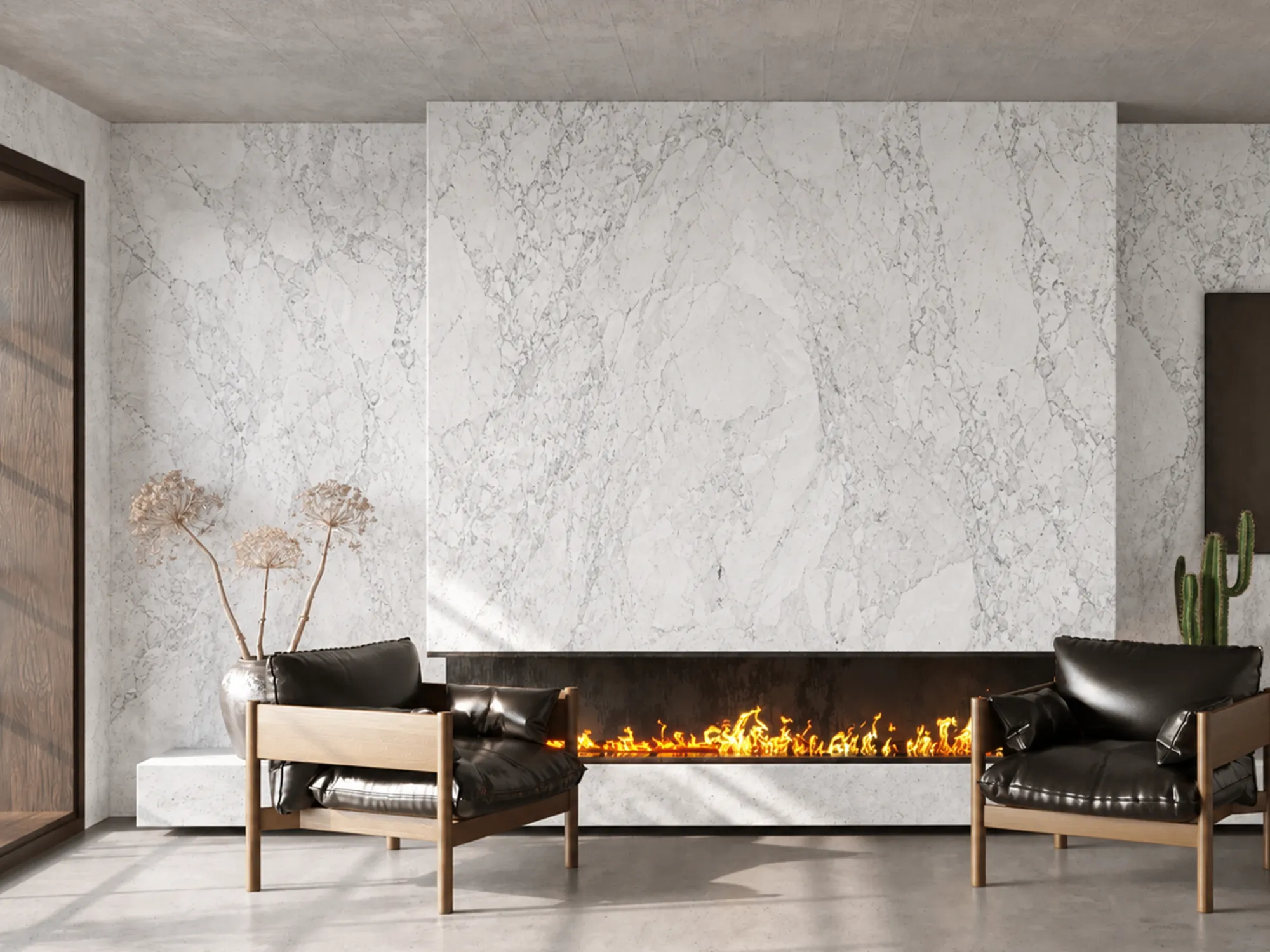 Bianco Carrara marble fireplace surround and wall cladding with fine gray veining in a living room with two black leather armchairs.