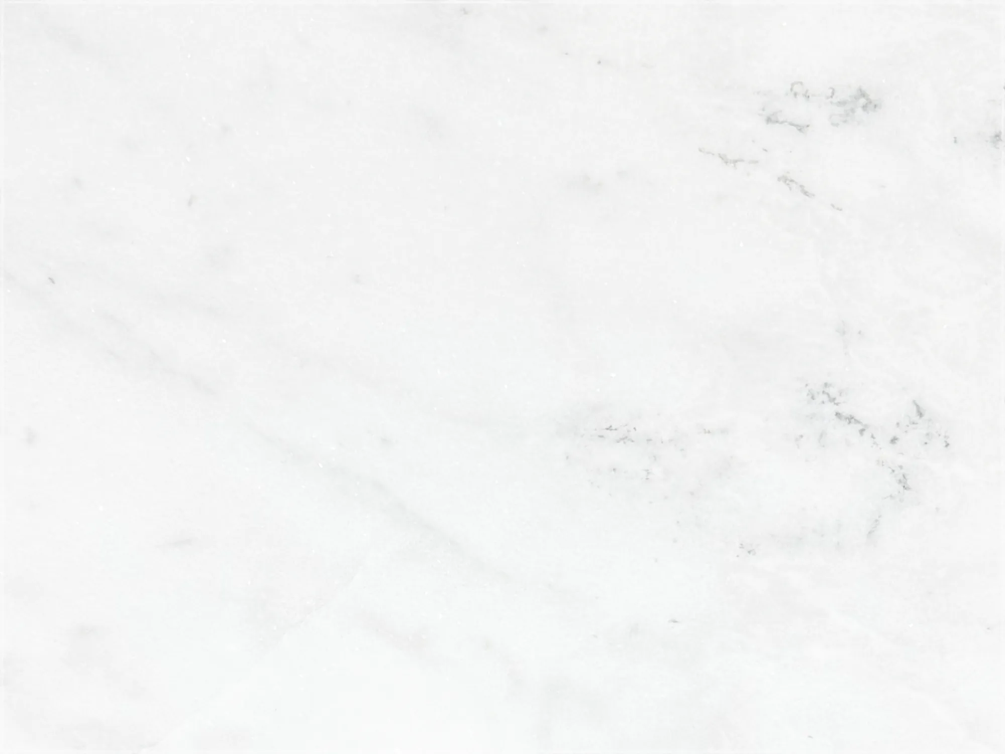 Mugla White marble tile with a predominantly white background, delicate gray veining, and soft feathered markings.