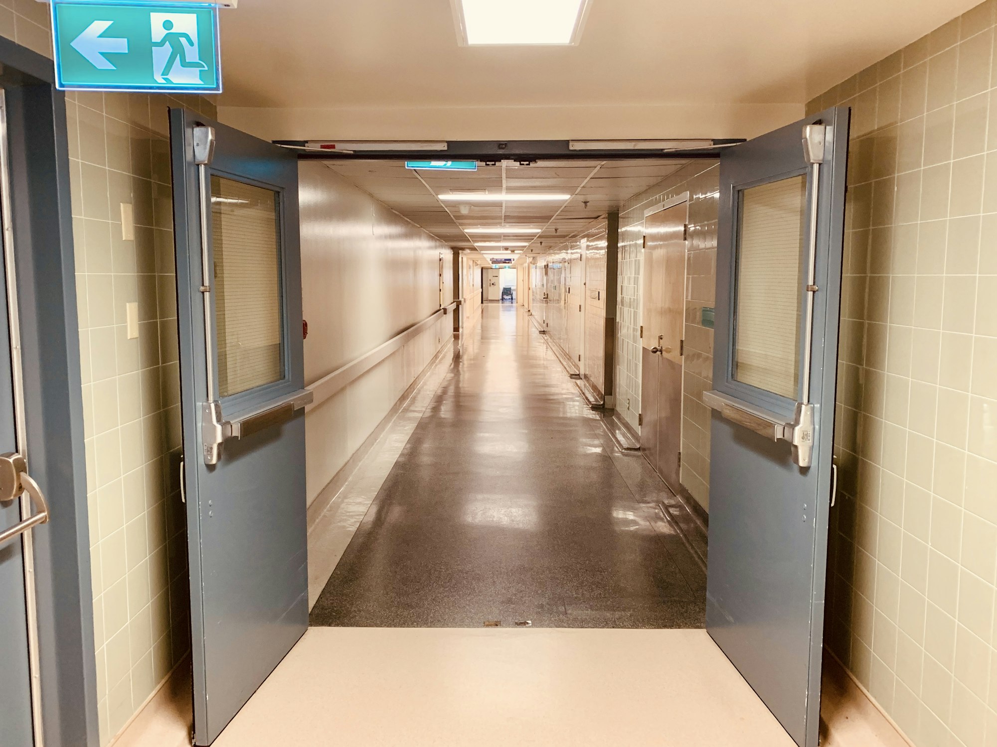 Hospital corridor with double doors and an exit sign