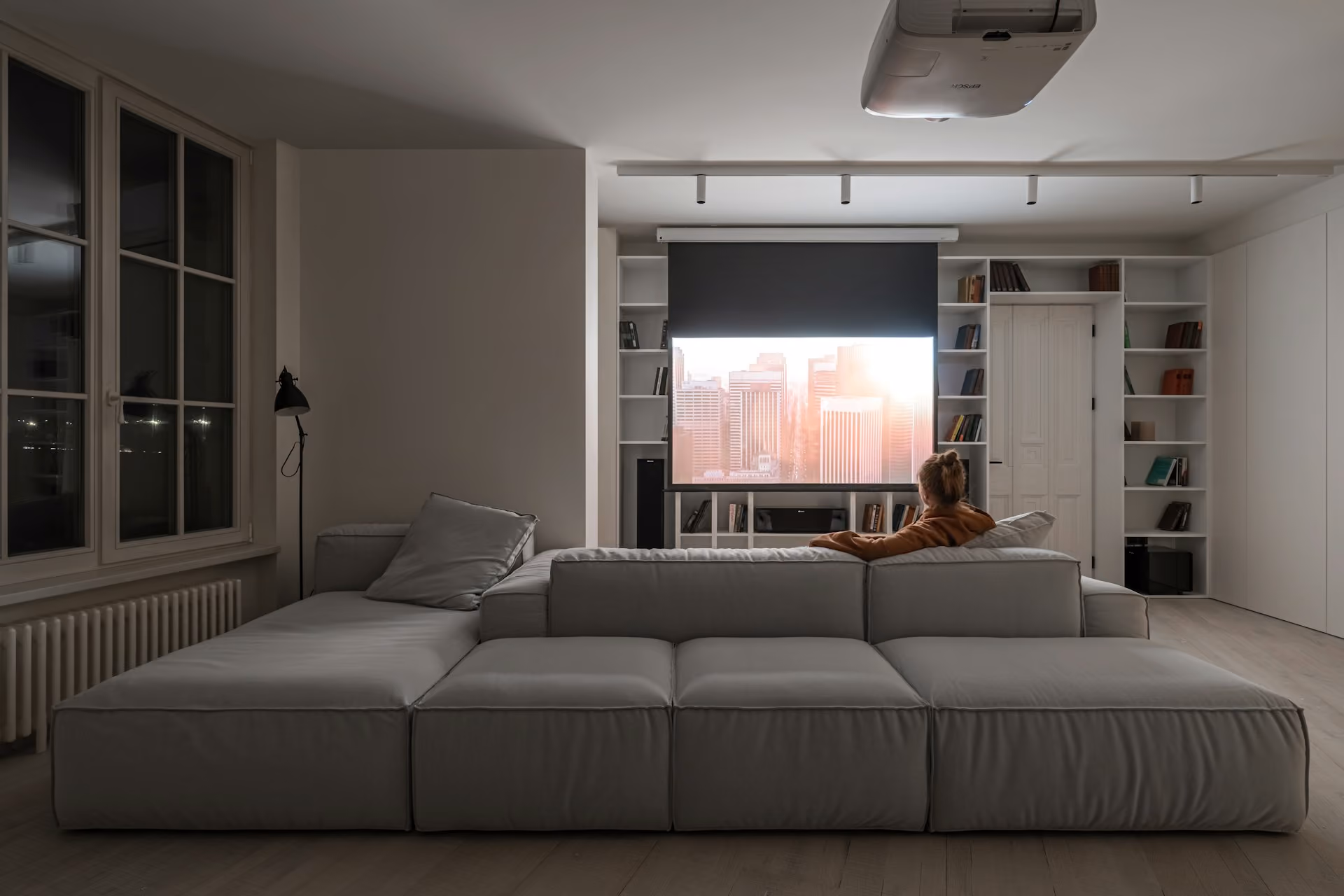 Home cinema living room with a large sofa and projection screen