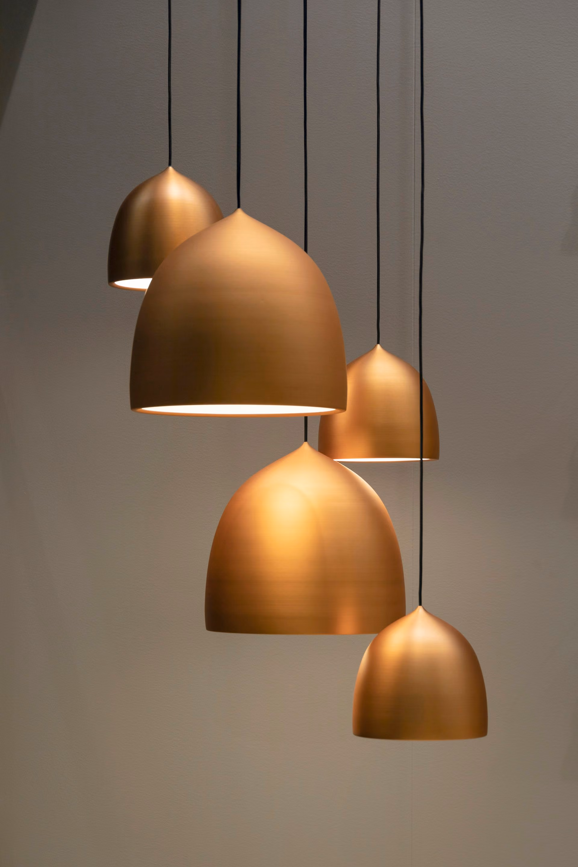Copper acoustic pendant lights hanging over a table
