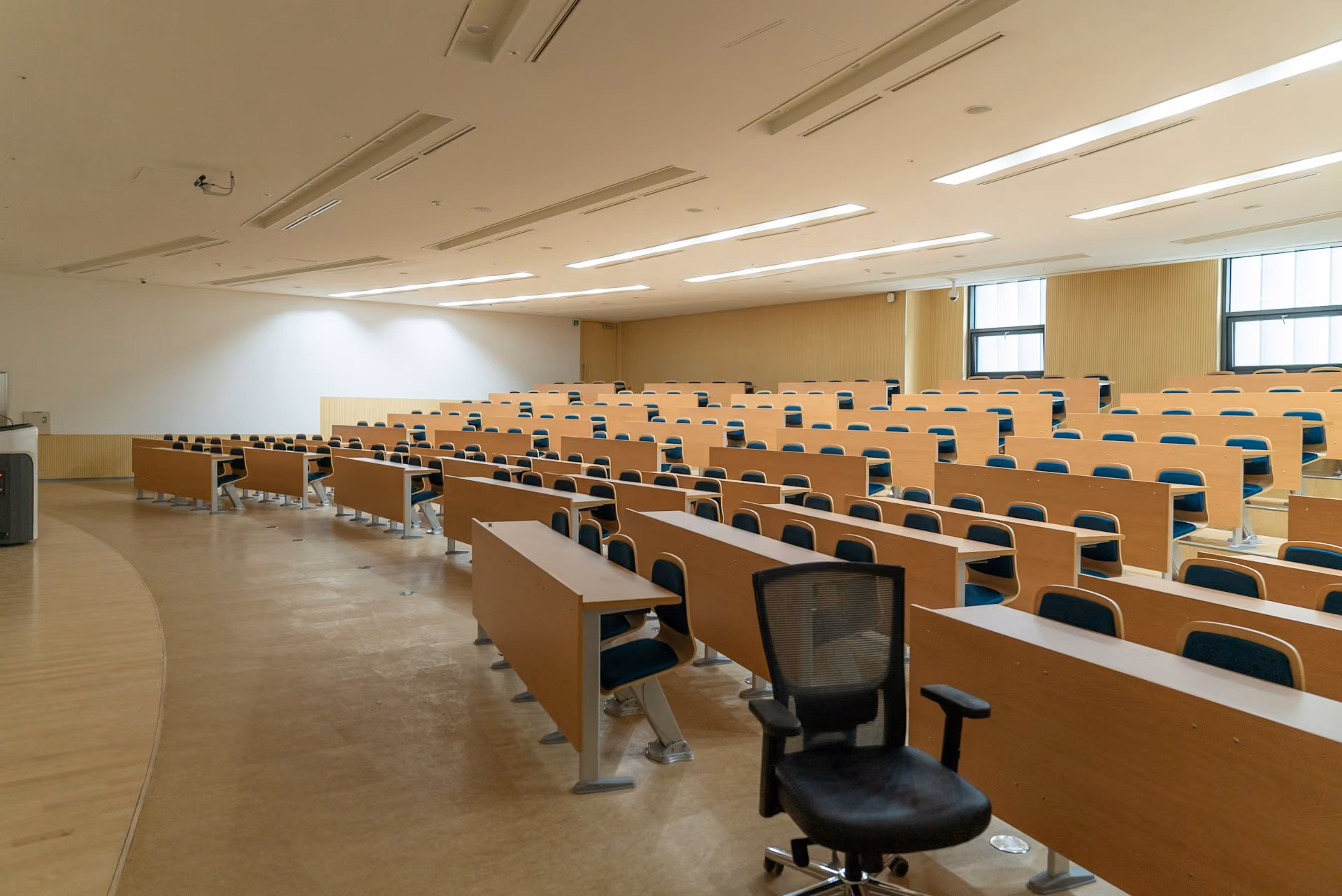 Empty lecture theatre with rows of timber desks ready for acoustic testing
