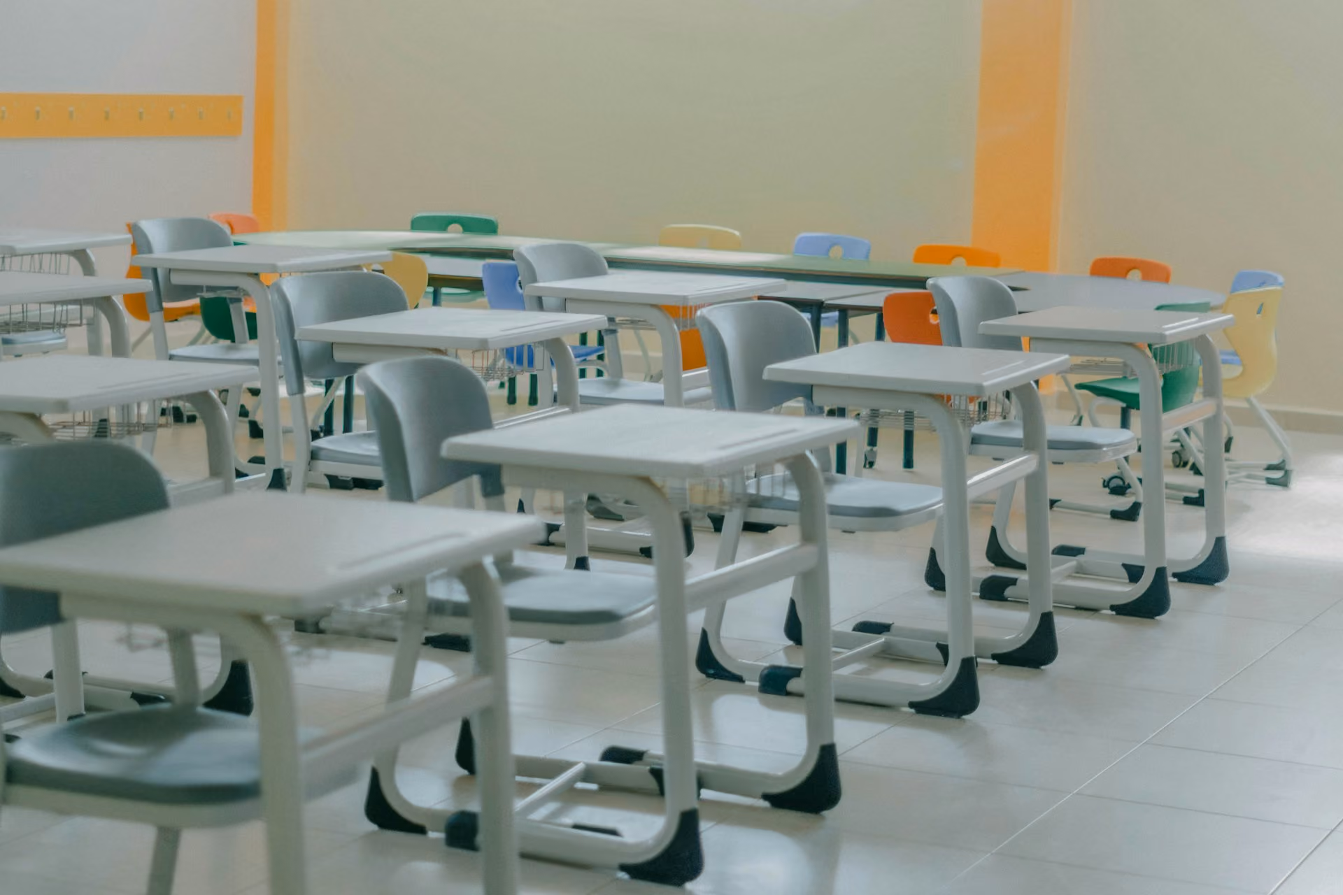 Primary classroom with rows of pale desks and chairs awaiting pupils