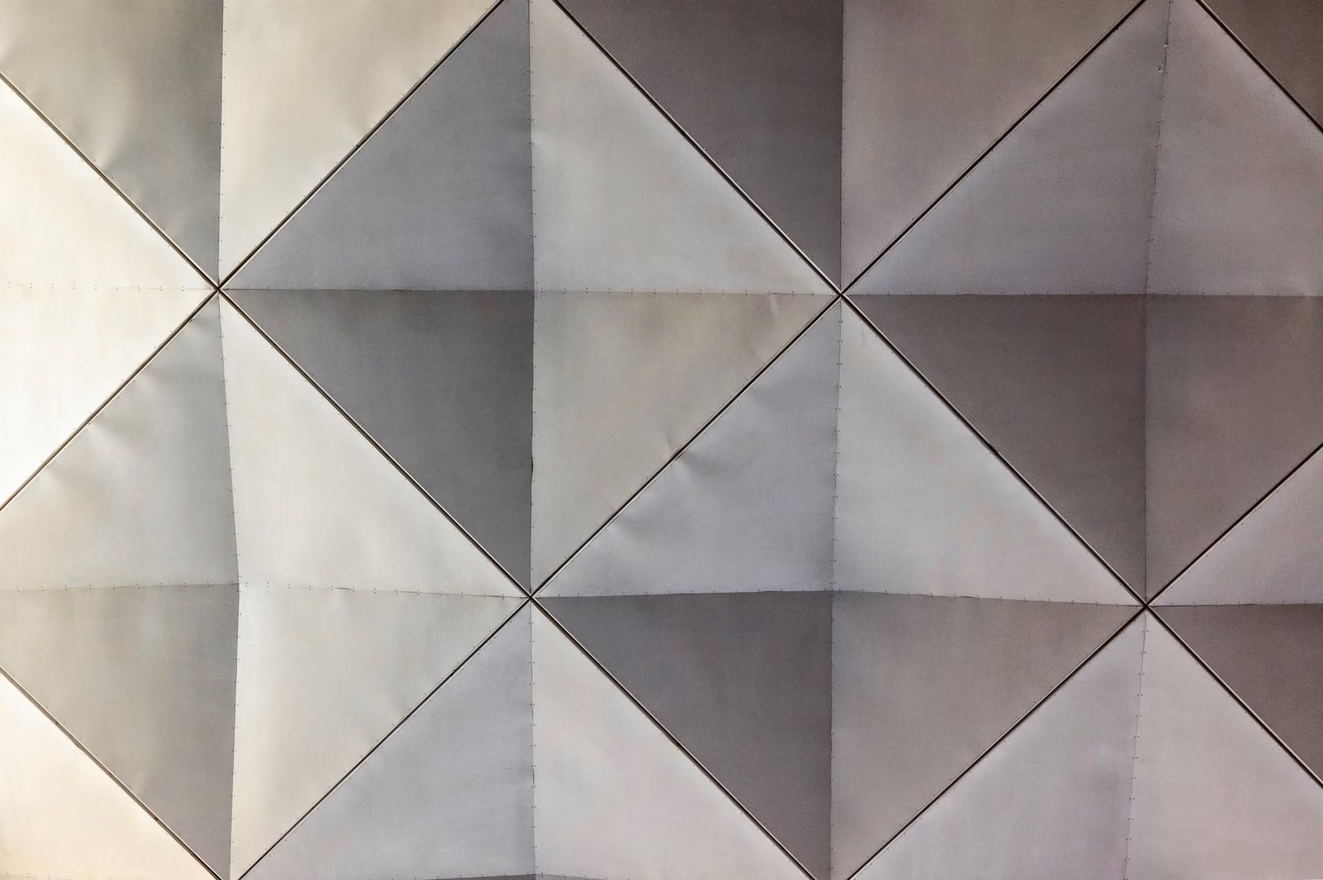Grey fabric acoustic wall panels in a faceted pyramid pattern