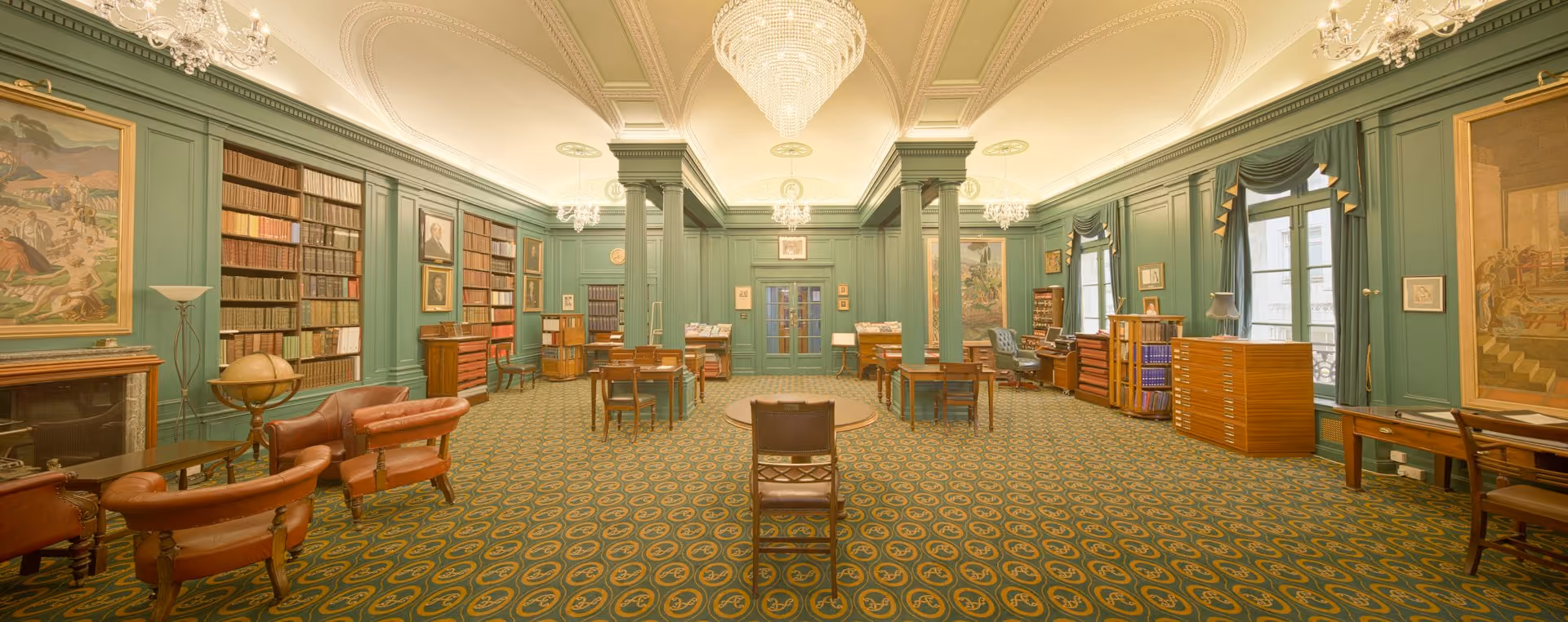 Traditional library reading room with bookshelves, columns and patterned carpet