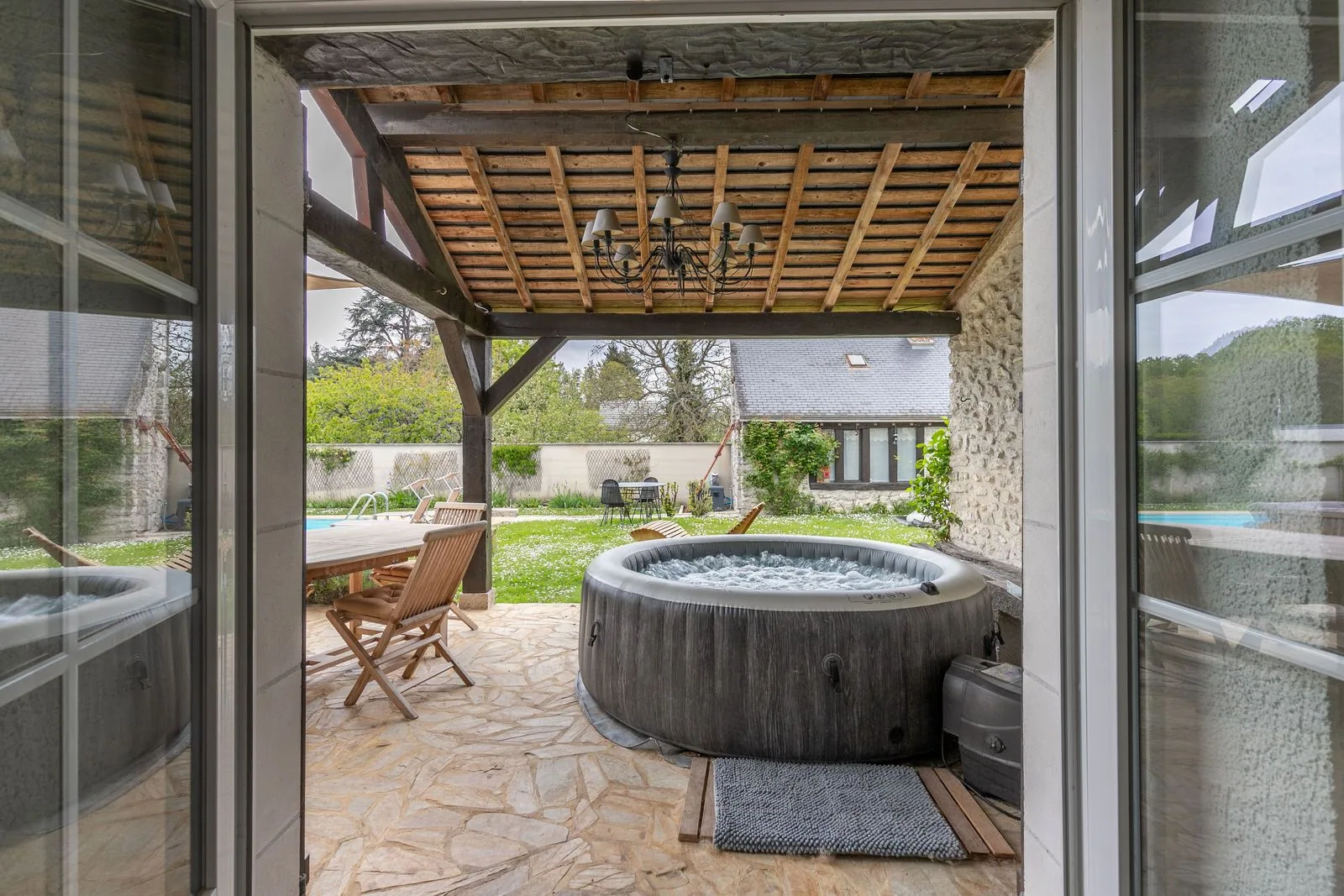 Le jacuzzi sous la terrasse couverte