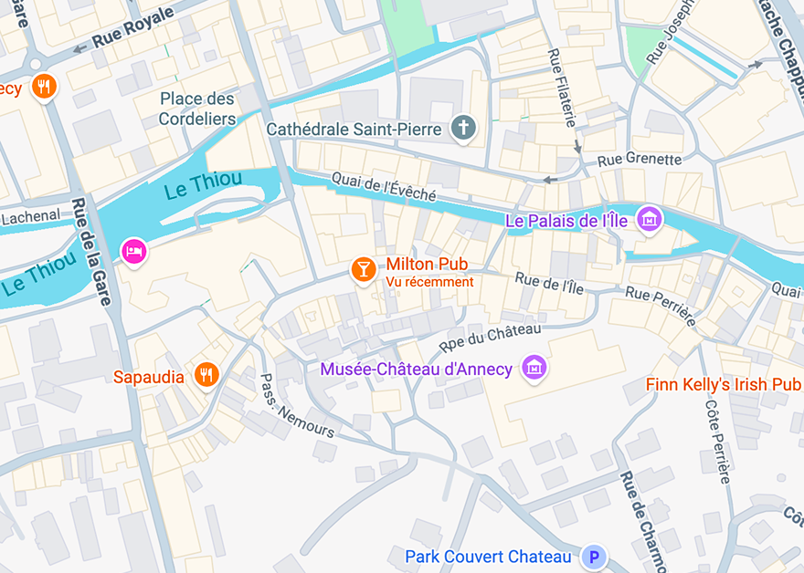 Map of Annecy, France, highlighting streets near Le Thiou canal including Rue Royale, Rue de la Gare, Quai de l'Évêché, Rue du Château, and notable places like Cathédrale Saint-Pierre, Musée-Château d'Annecy, Milton Pub, Sapaudia restaurant, Finn Kelly's Irish Pub, Le Palais de l’Île, and Park Couvert Chateau.