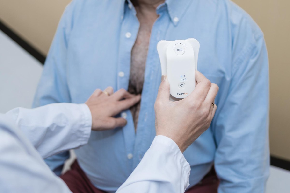A clinician placing the HeartEye ECG device on a patient’s chest.