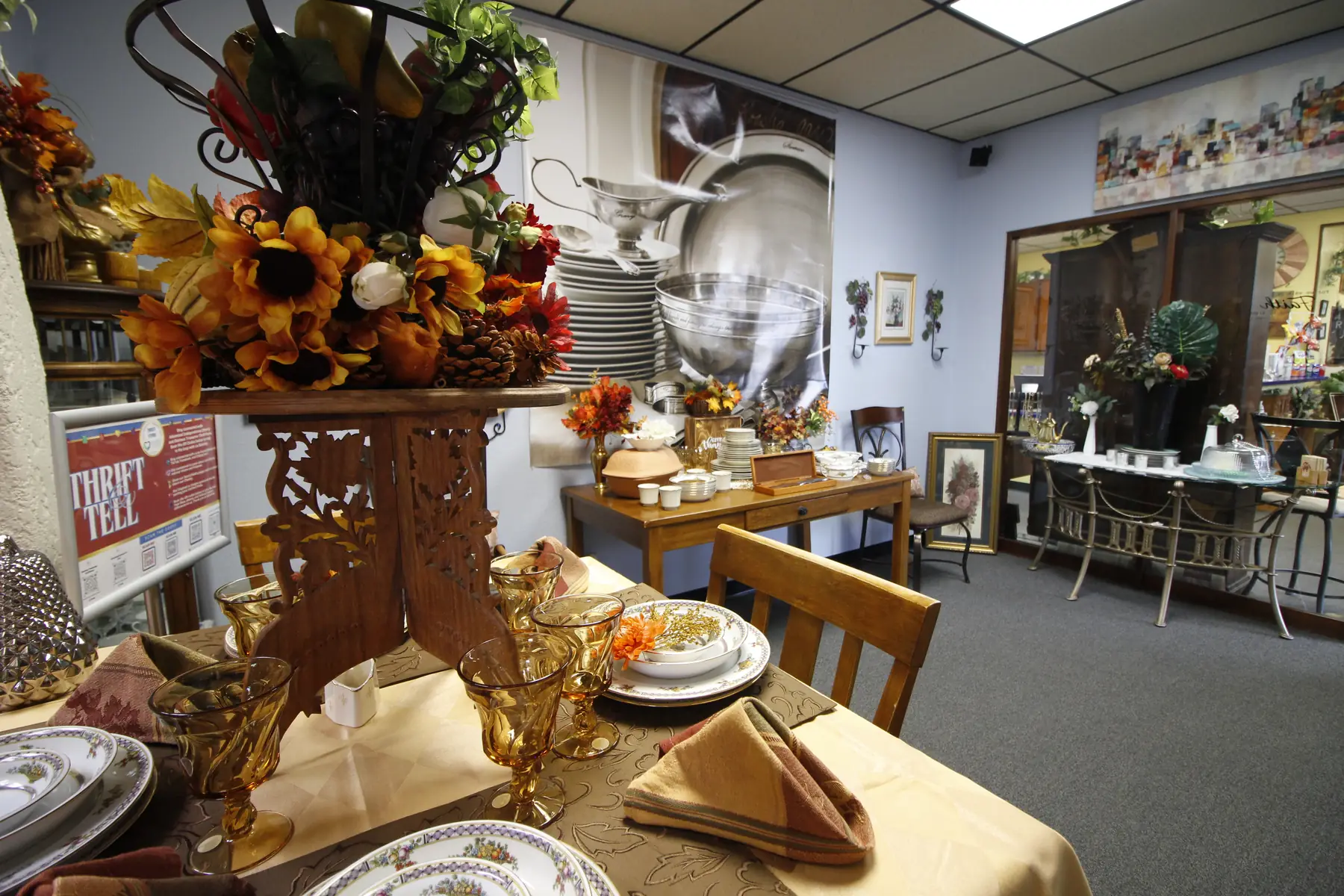 A harvest table setting at Glorious Treasures with a sunflower centerpiece, gold-rimmed china and amber glassware